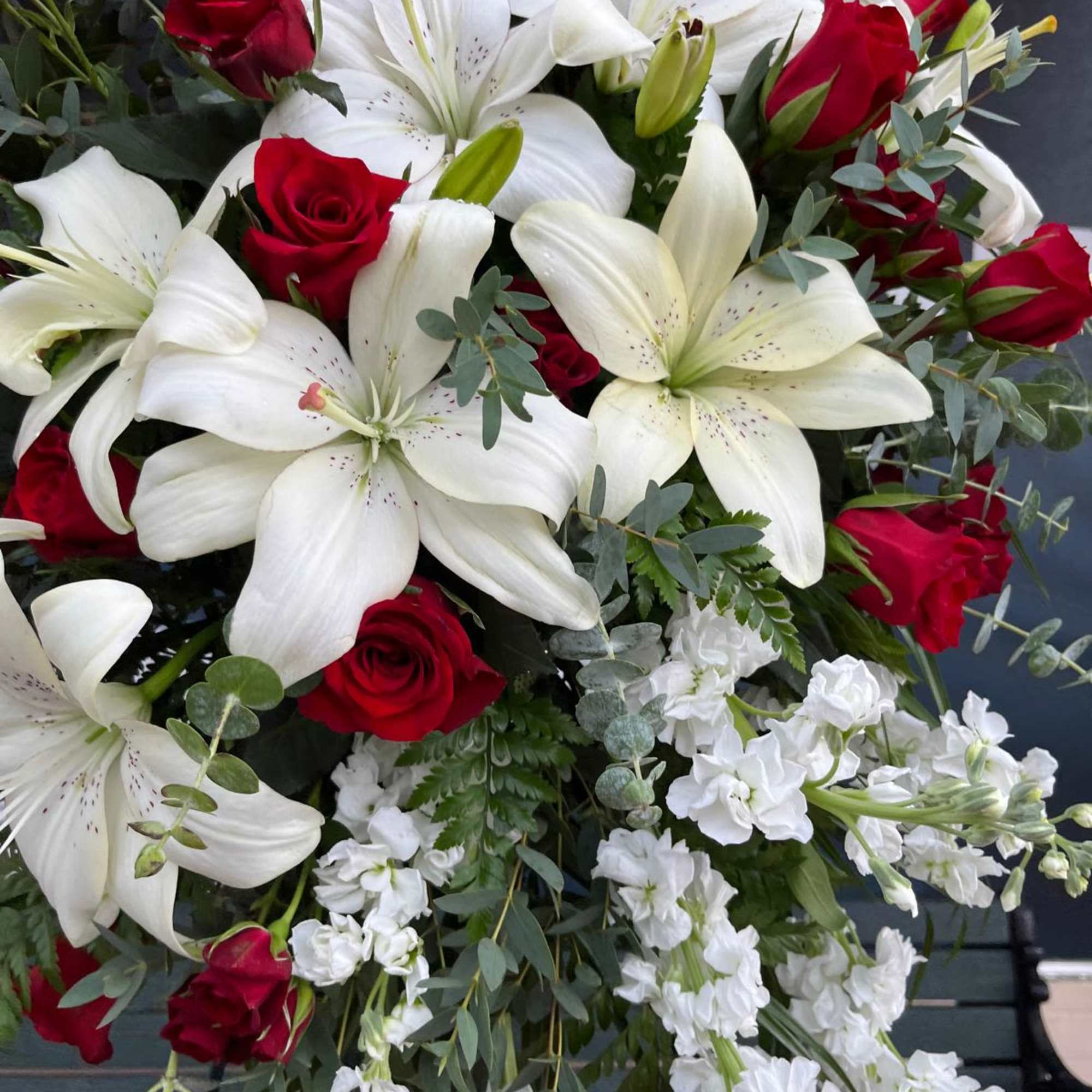 Bouquet of red roses, white lilies, and white flowers with greenery