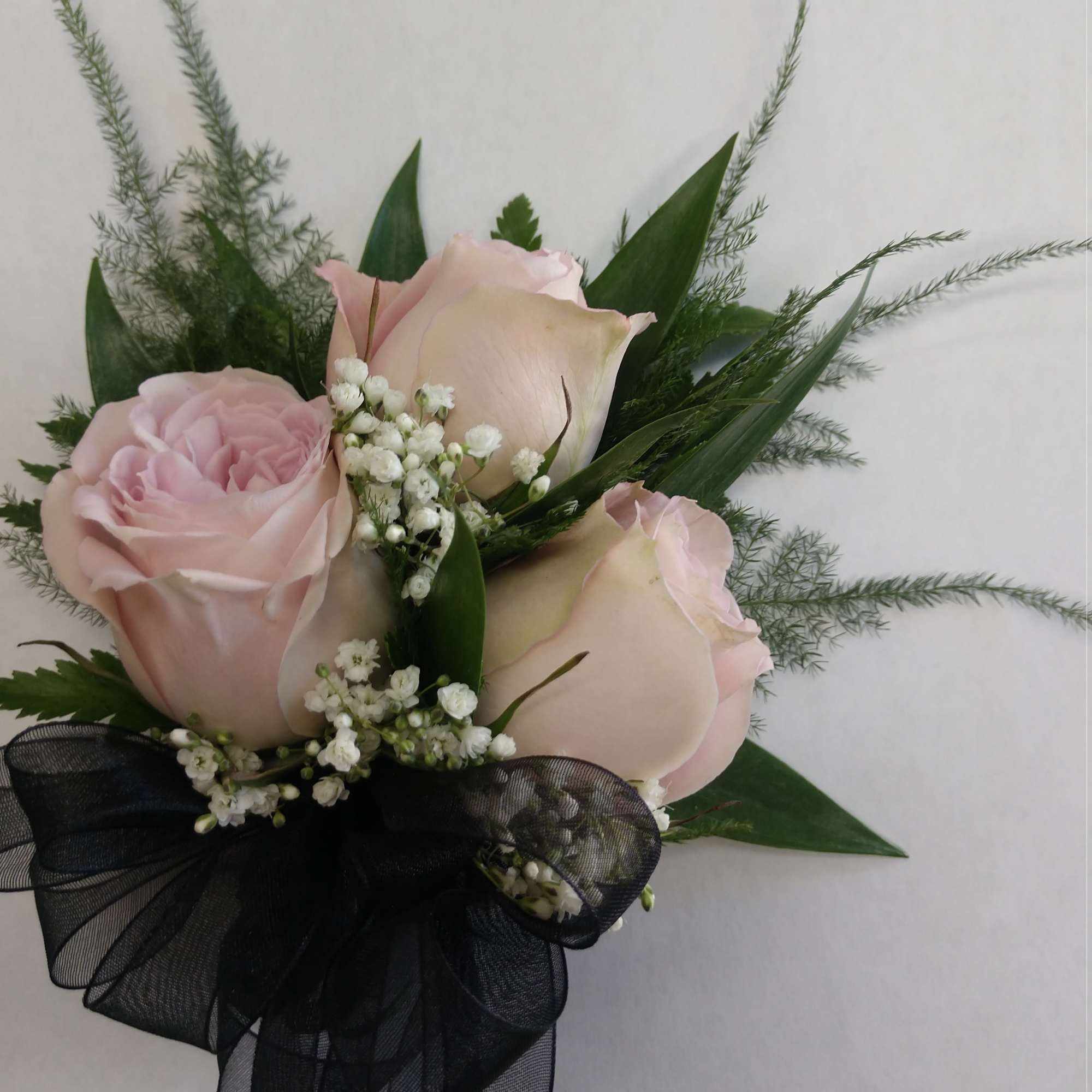 Pink roses with baby's breath and a black ribbon bow