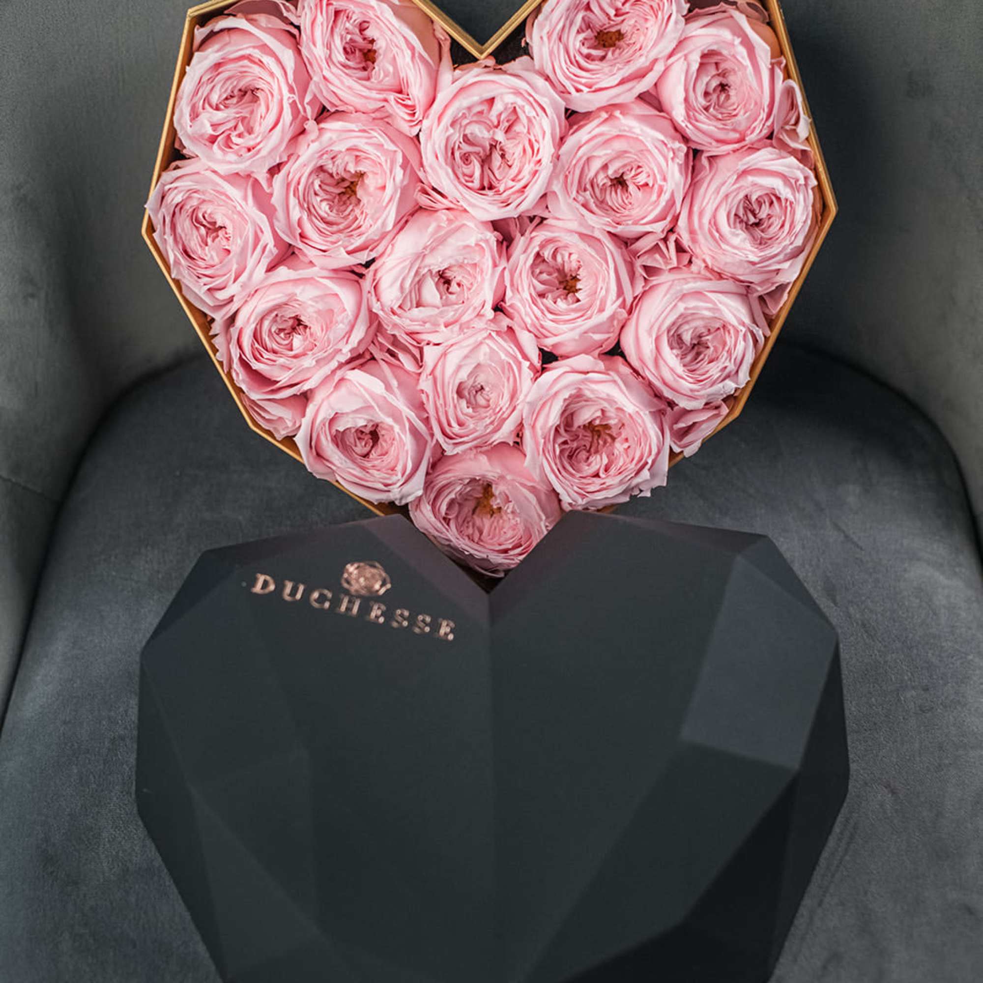 Heart-shaped box of pink roses with a black lid