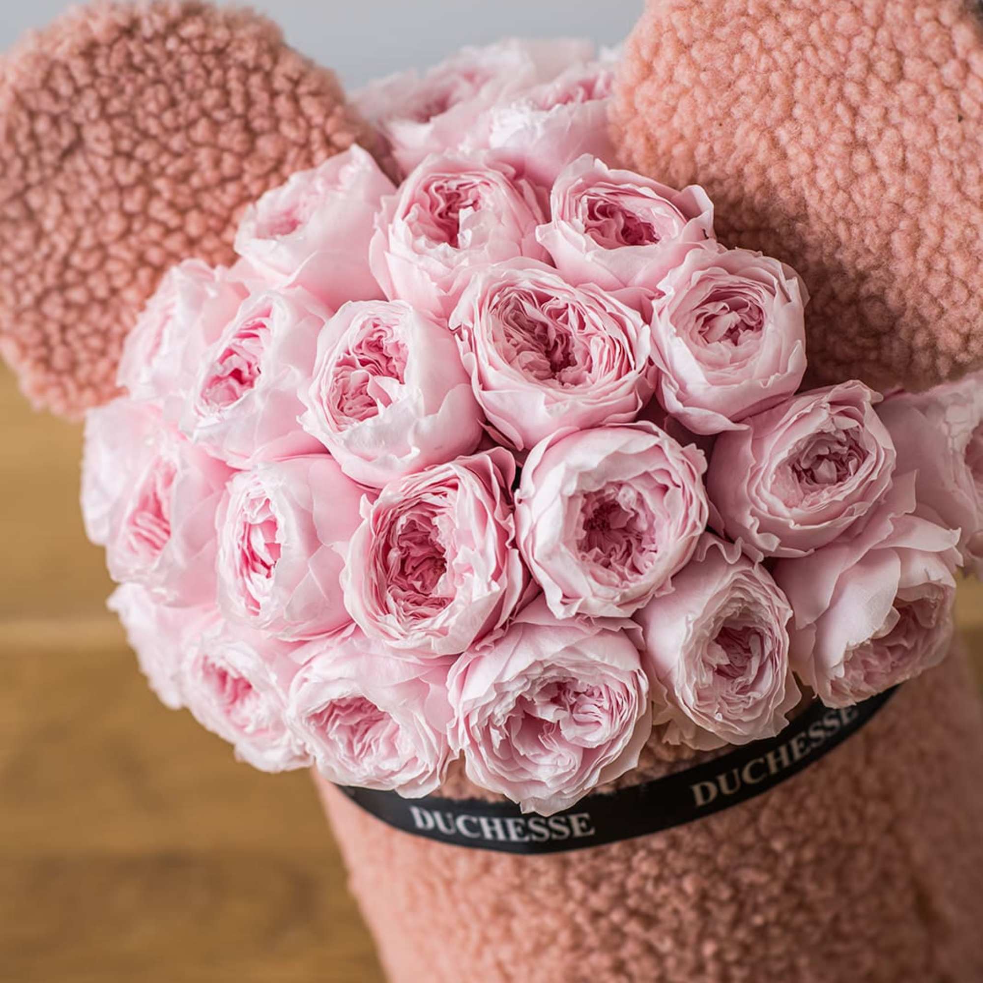 Pink ranunculus bouquet in a plush teddy bear-shaped holder