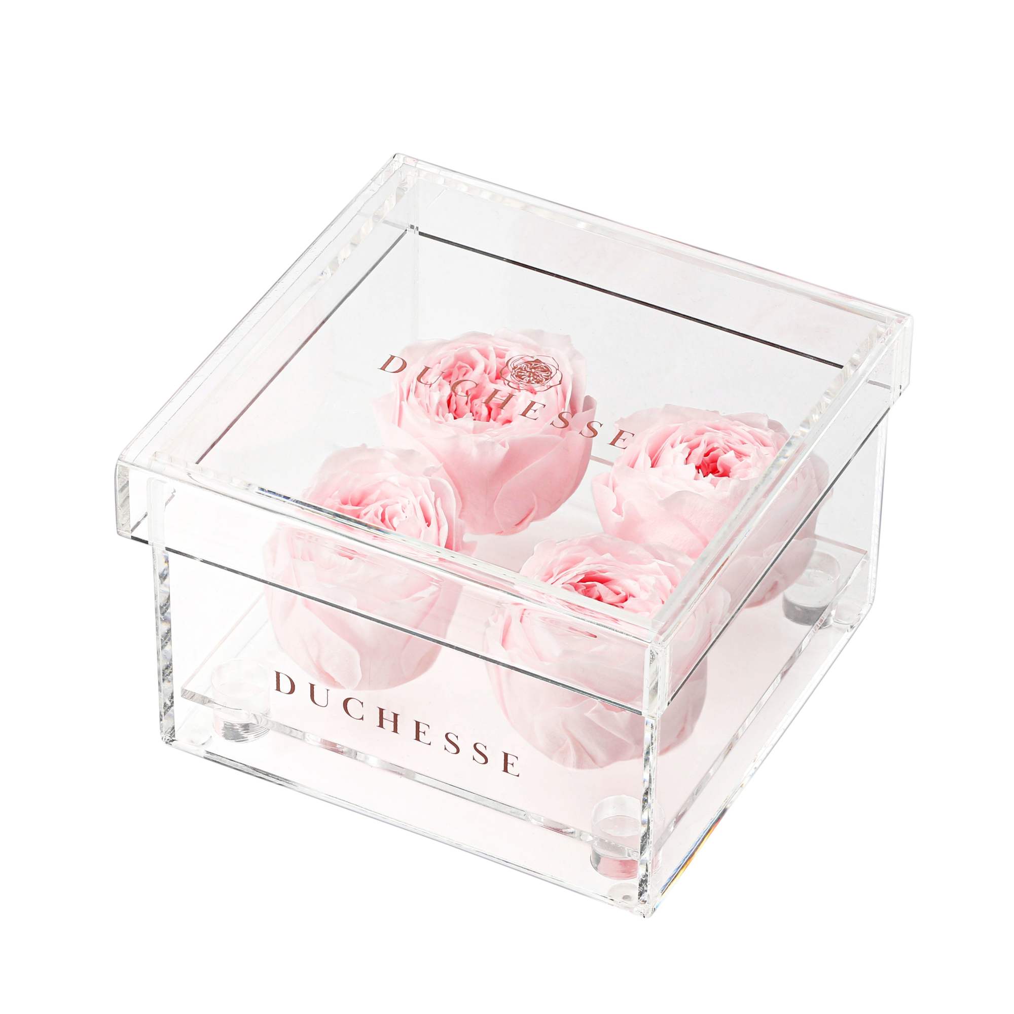 Four pale pink roses in a clear acrylic box