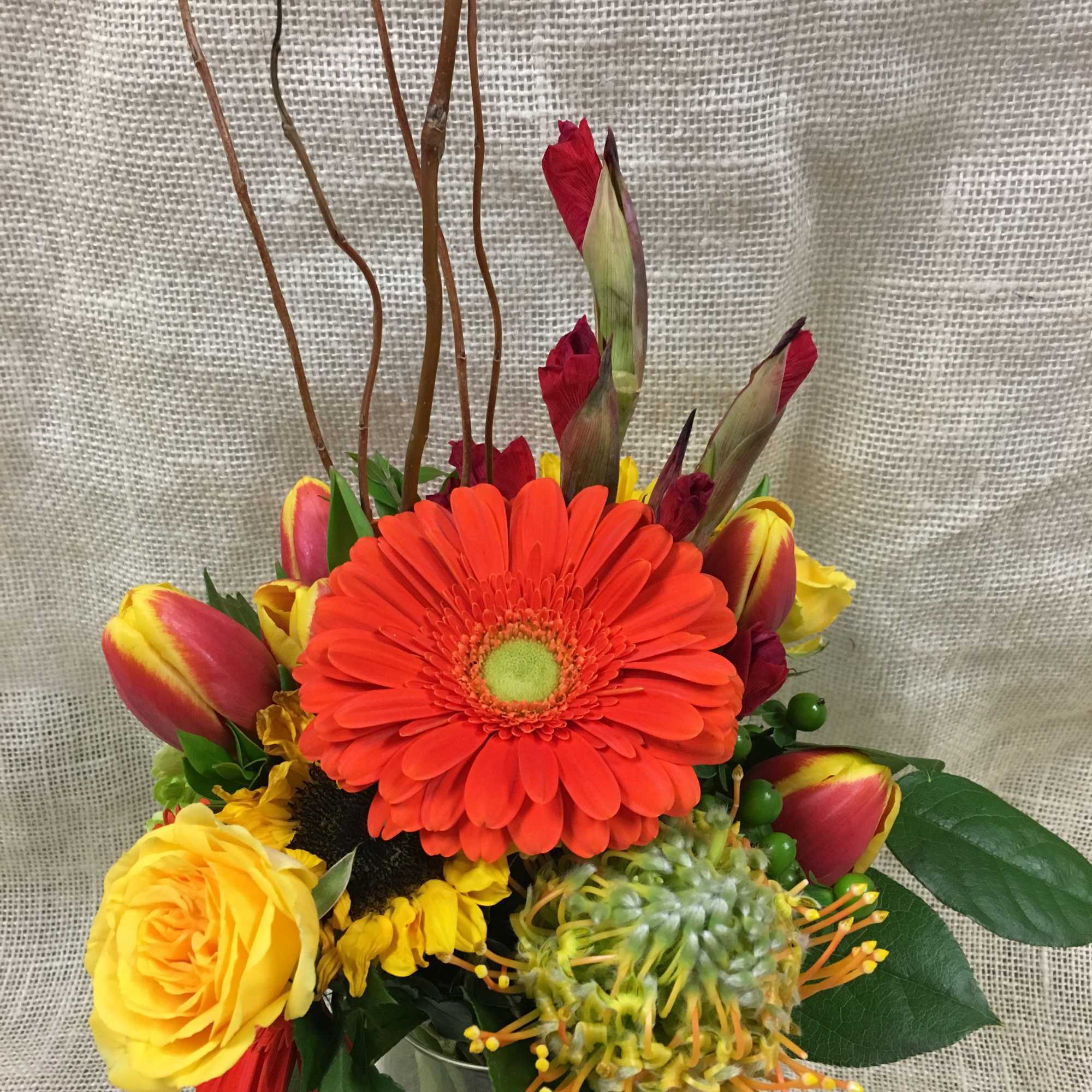 Bright mixed bouquet with a large orange gerbera and yellow roses in a glass vase