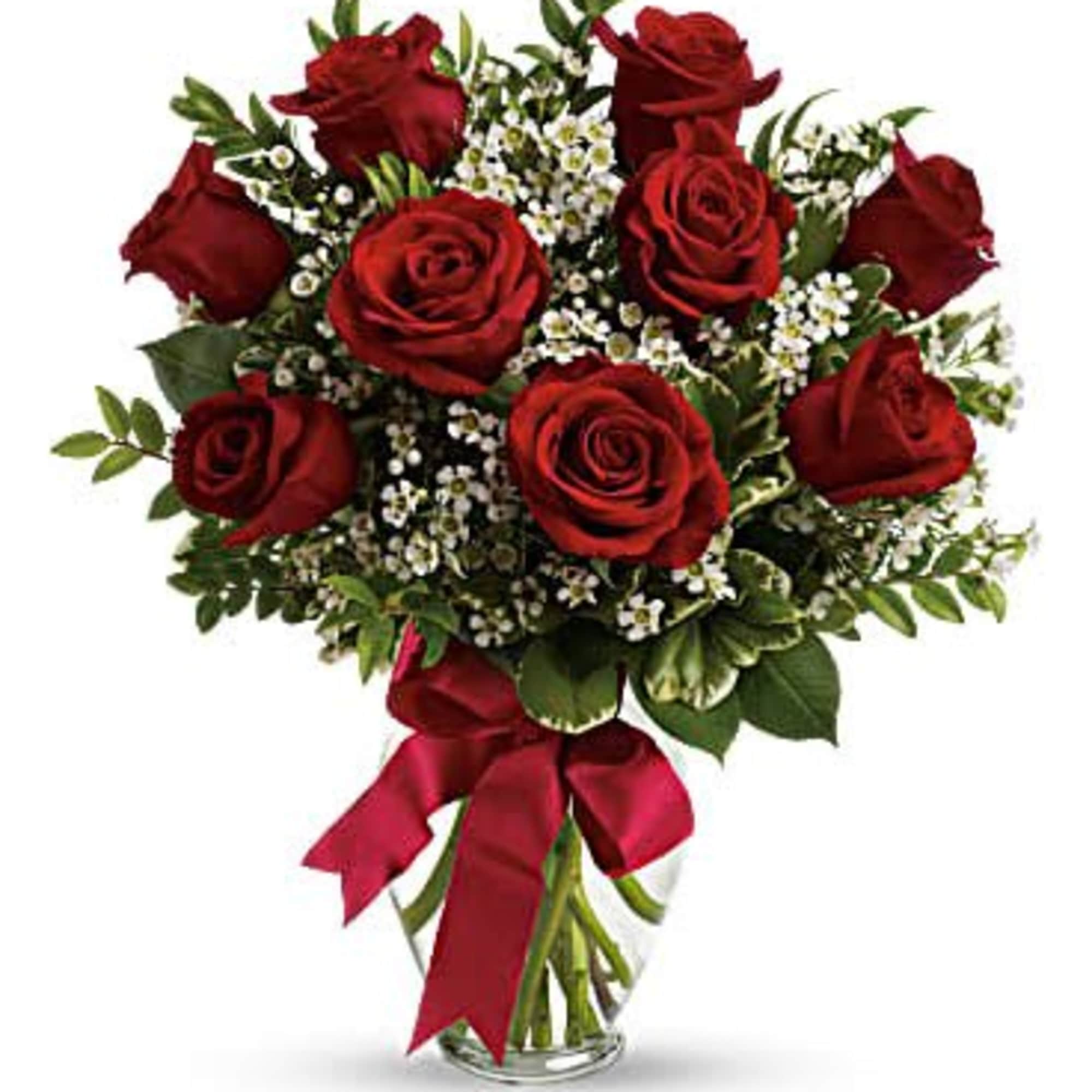 Bouquet of red roses with white filler flowers in a glass vase