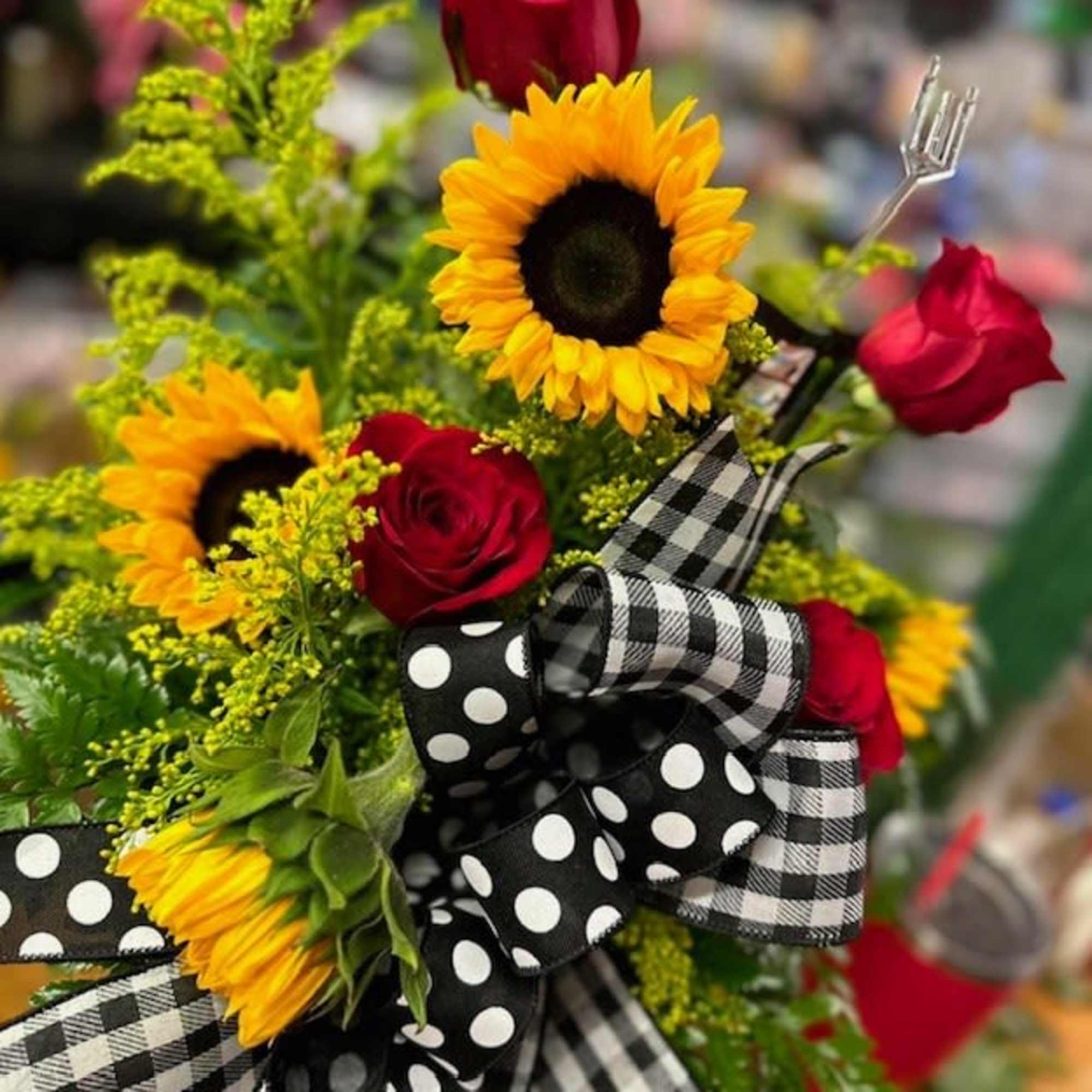Bouquet of sunflowers and red roses with black-and-white ribbon bows