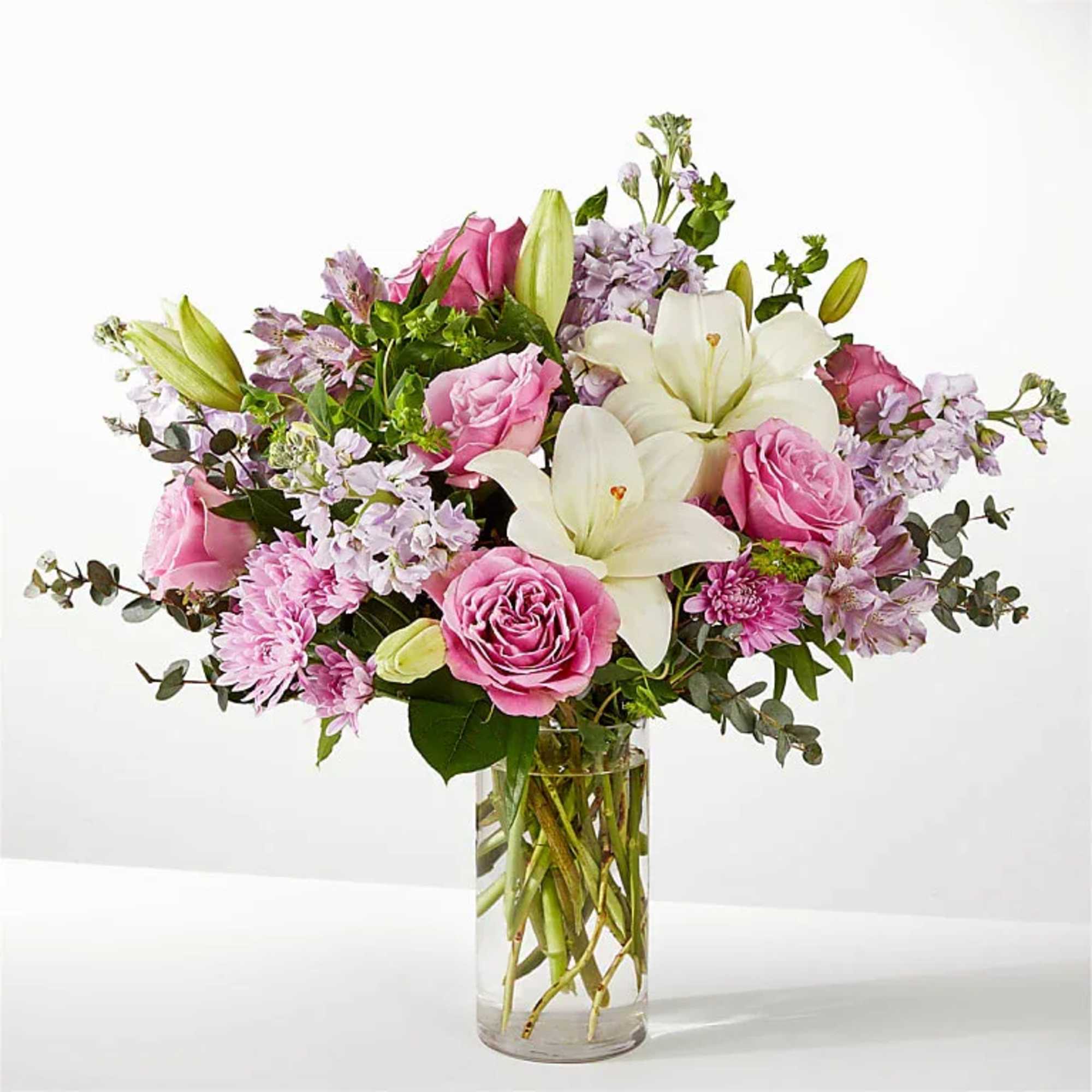 Pink roses and white lilies in a clear glass vase