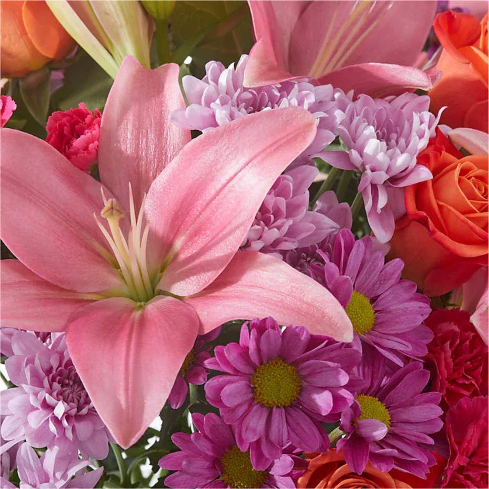 Pink lily and mixed pink-purple flowers in a close-up bouquet