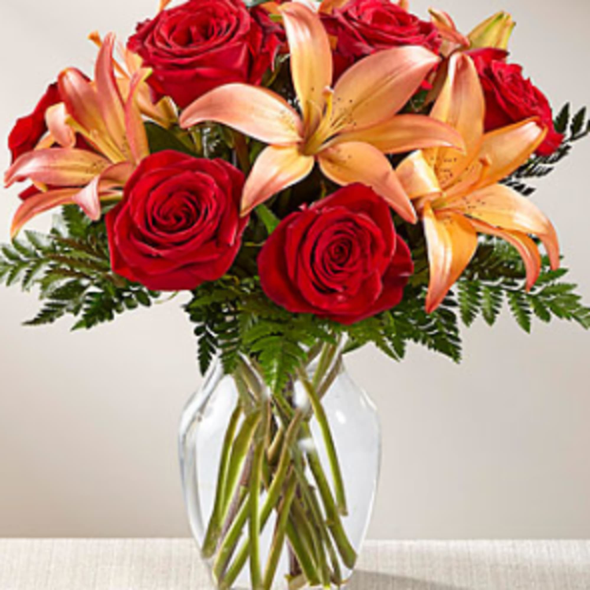 Rich red roses are paired with orange Asiatic Lilies to create a, photo 2 of 3