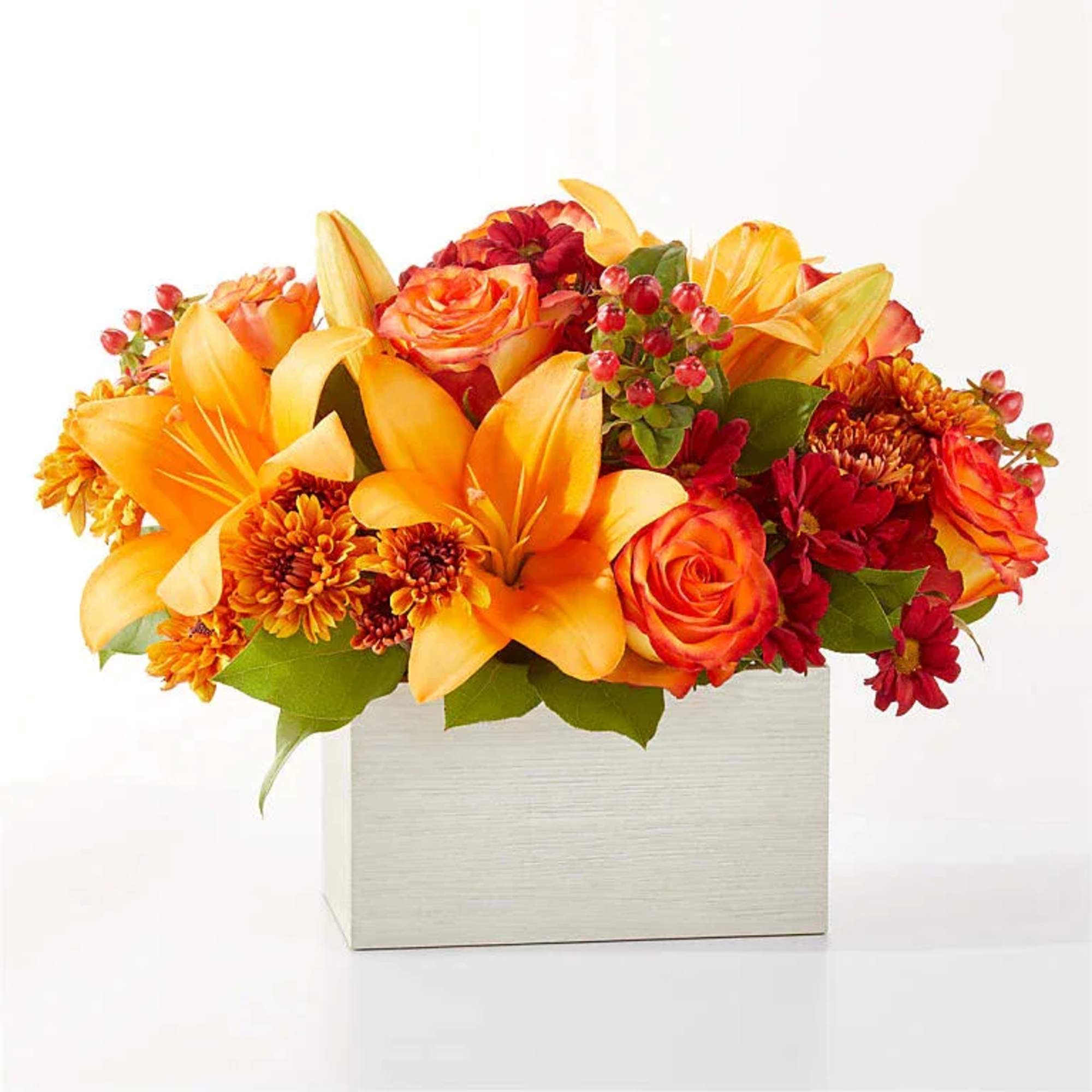 Step into autumn with fiery red and orange petals, expertly arranged to