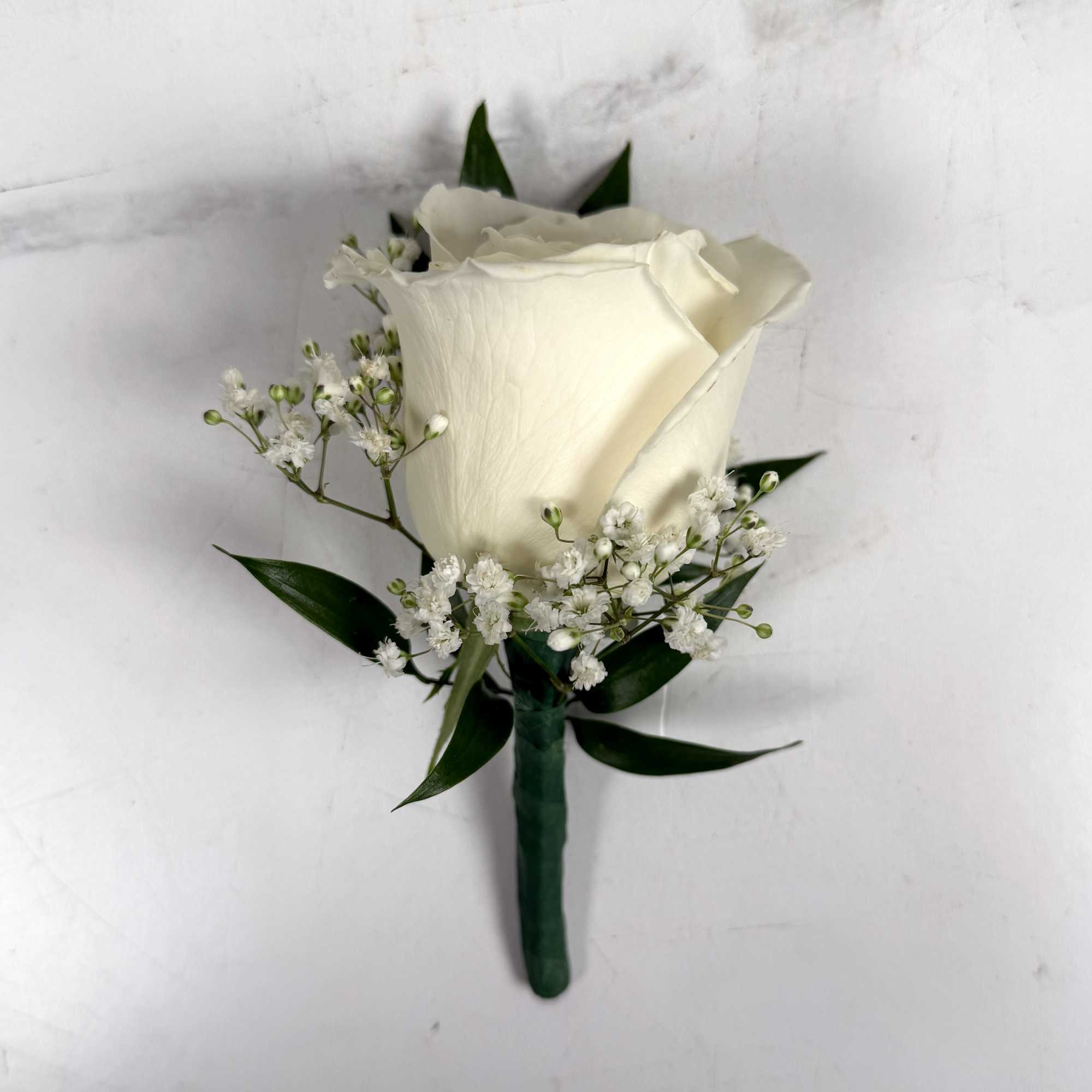 One white standard, full-sized rose with baby's breath makes up this classic