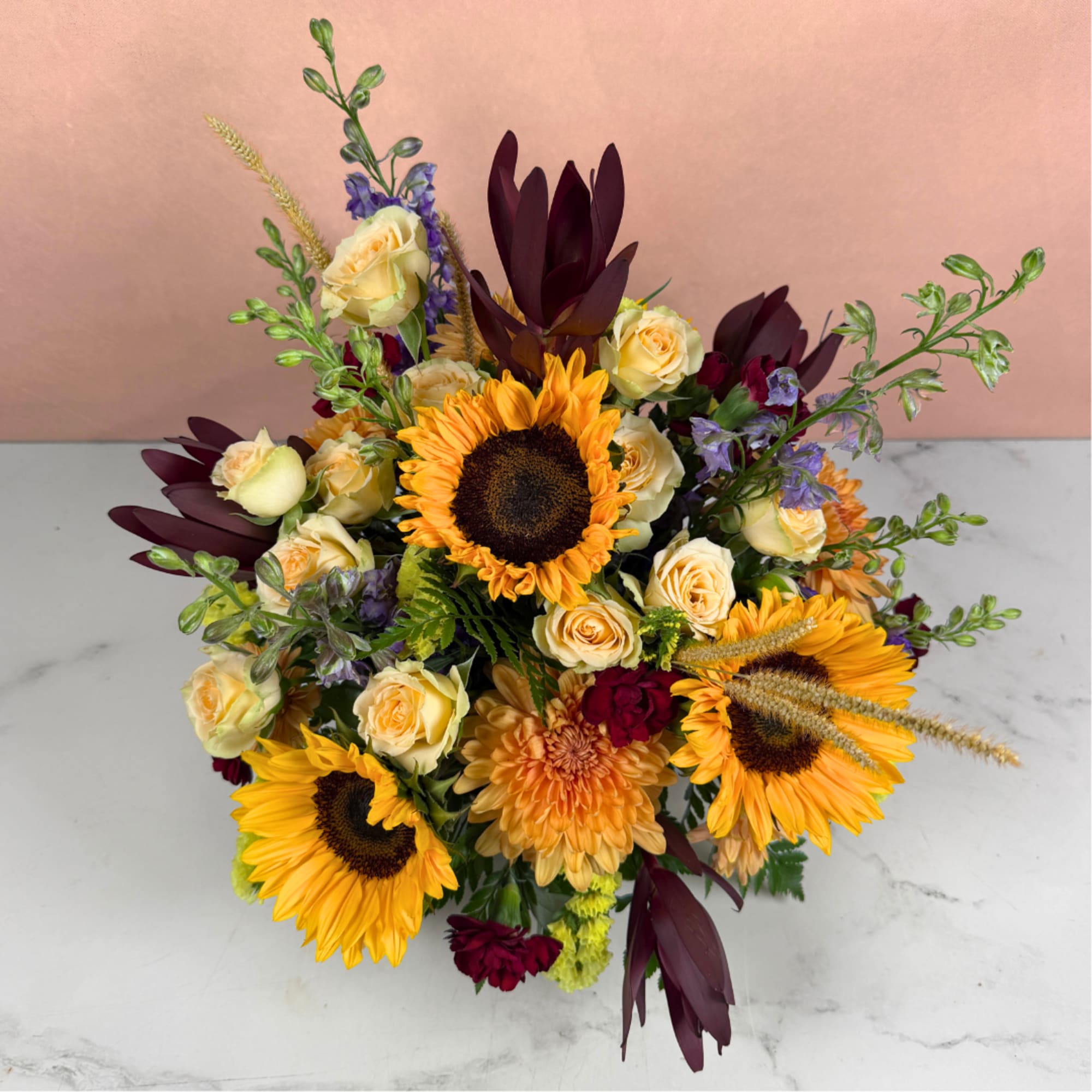 Bouquet with sunflowers, cream roses, and burgundy foliage
