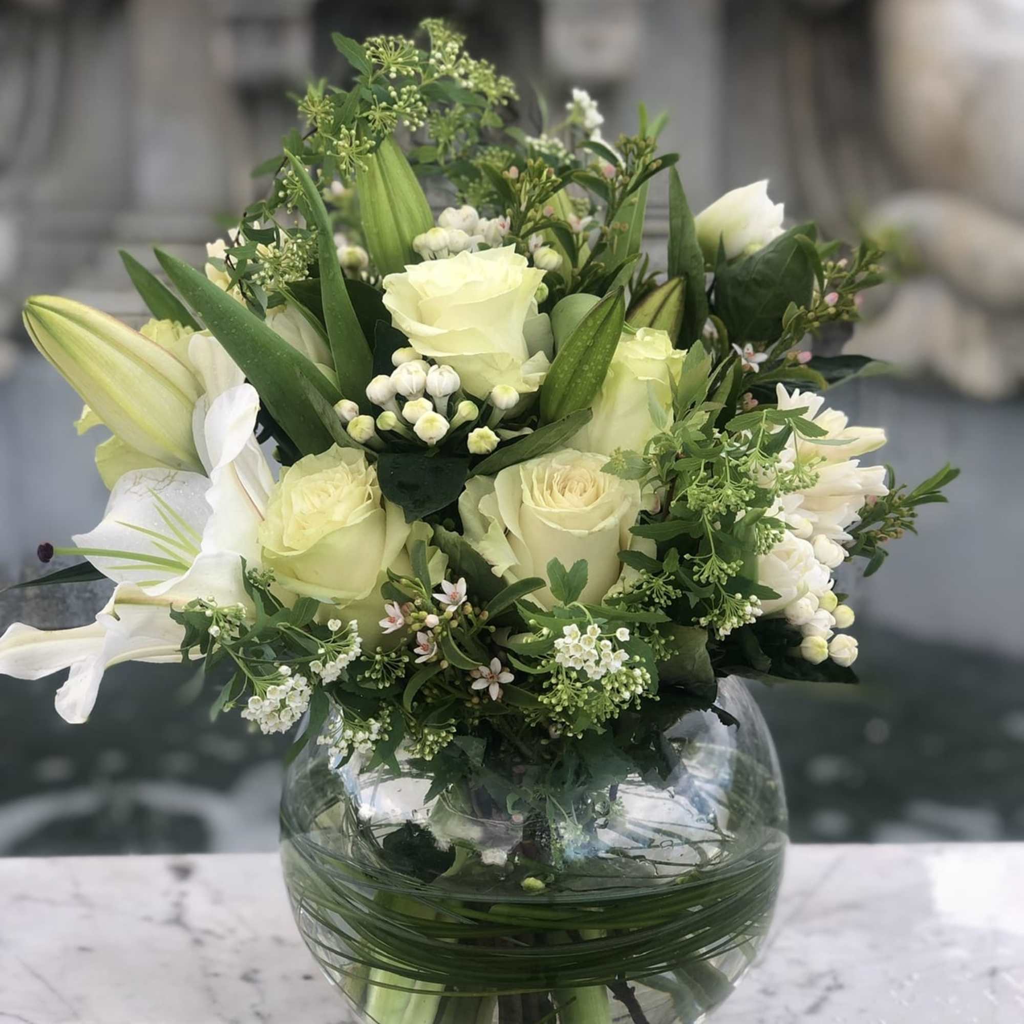 White rose bouquet in a round glass vase