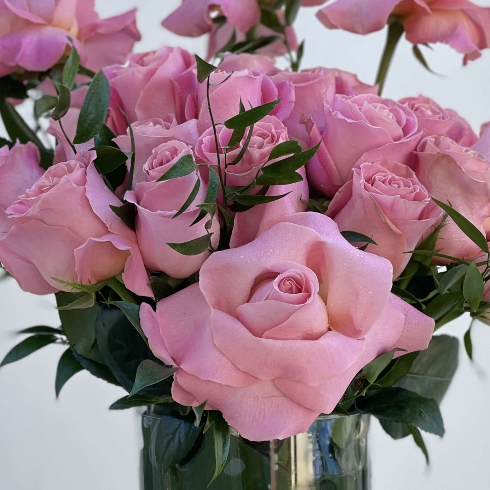 Pink roses and calla lilies in a clear glass vase