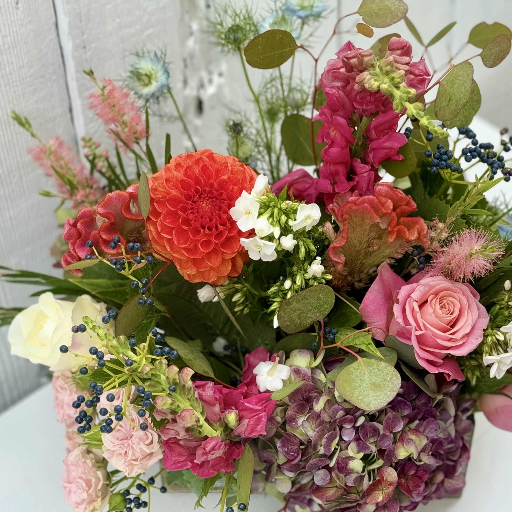 Mixed bouquet with pink roses, a red dahlia, and white blooms
