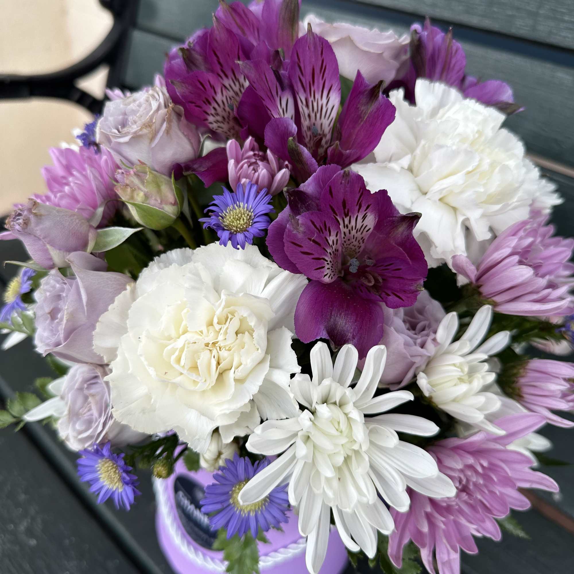 Bouquet of purple, white, and pink flowers in a lavender container