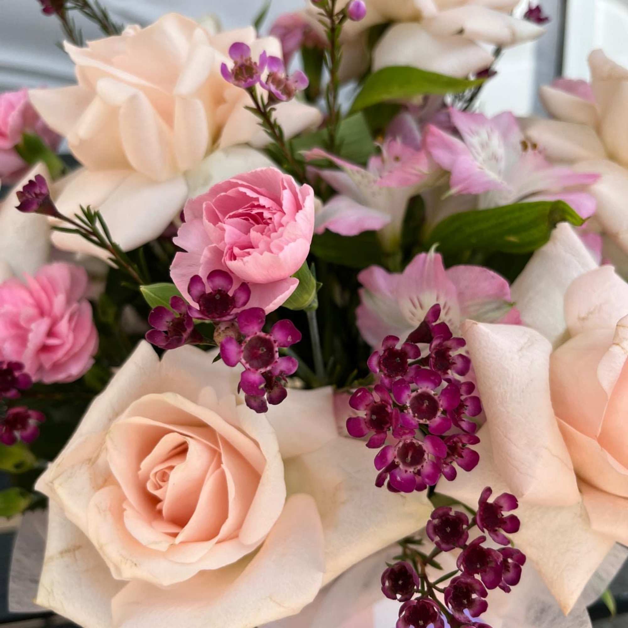 Bouquet of blush roses and pink flowers with purple accents