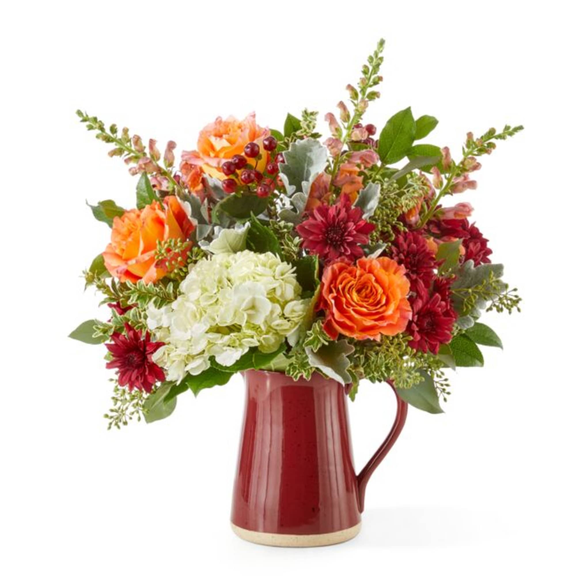 Bouquet of orange, red, and white flowers in a red pitcher vase