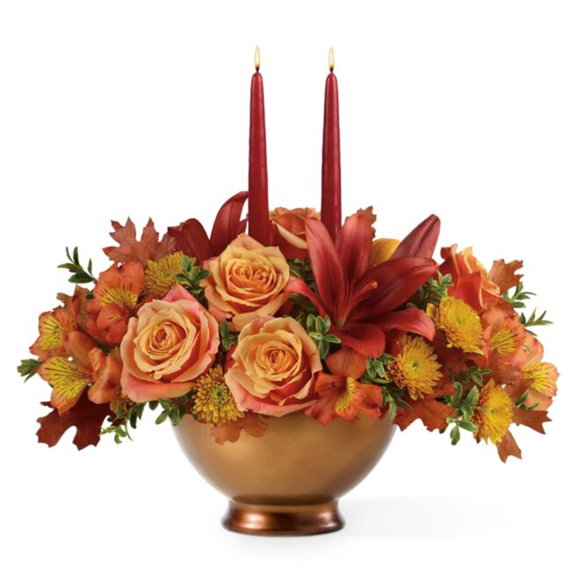 Autumn floral centerpiece with roses and two red taper candles in a gold bowl