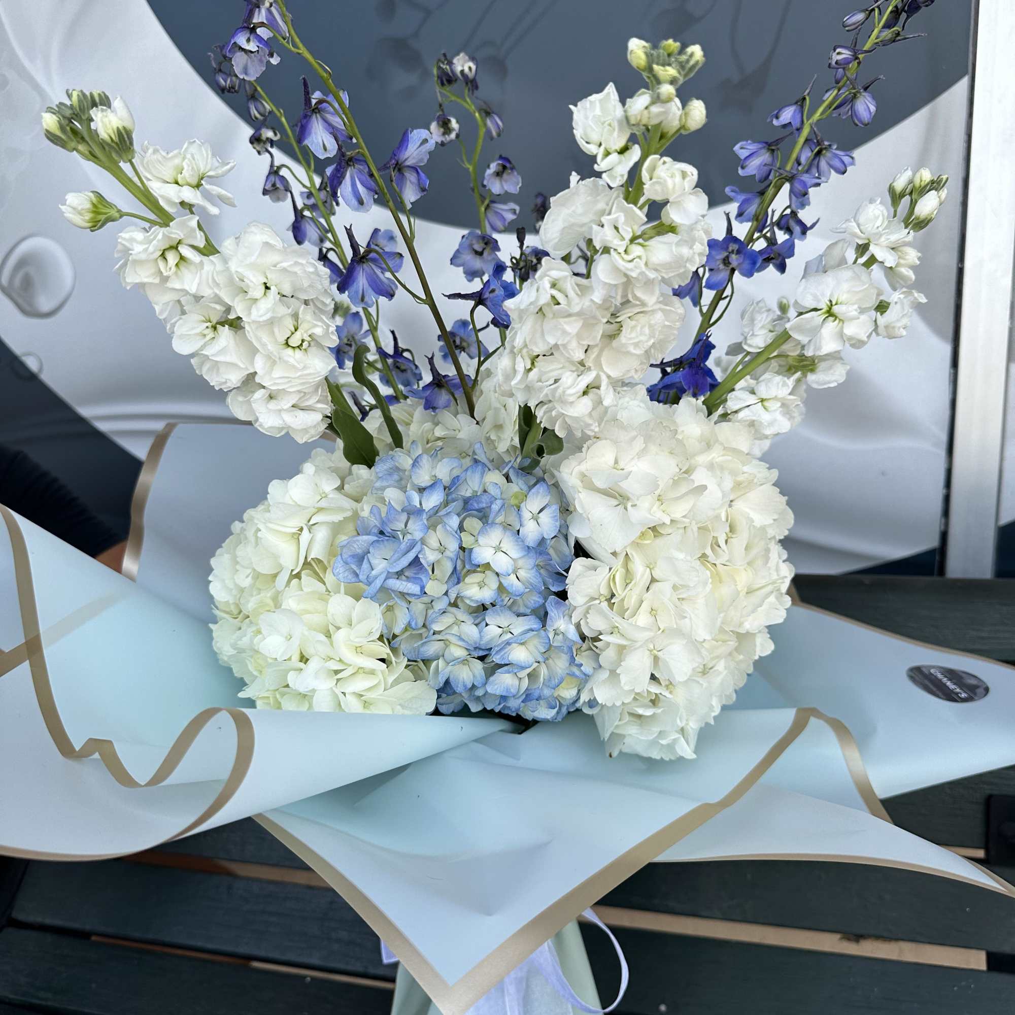 White and blue flower bouquet wrapped in pale paper