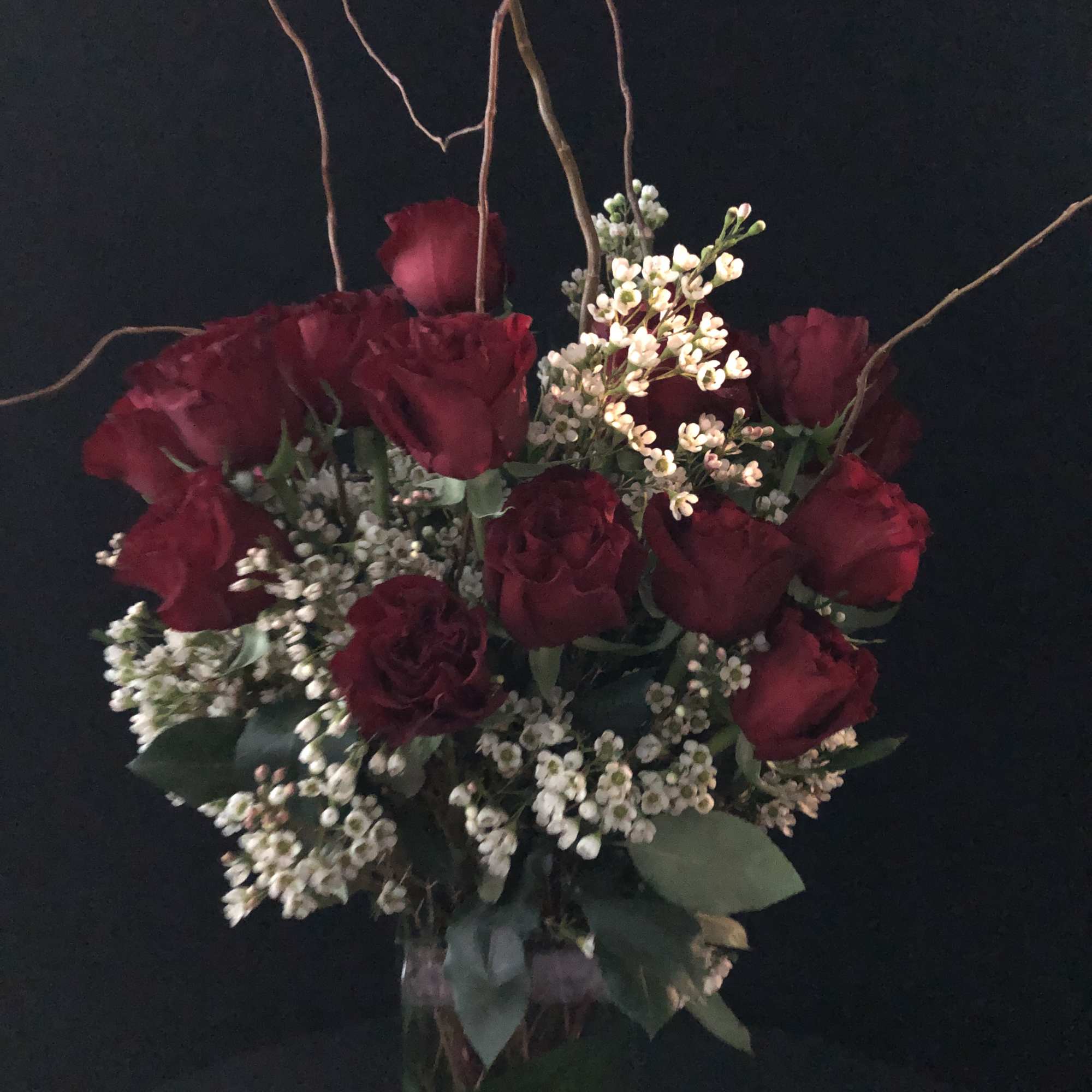 Bouquet of deep red roses with small white filler flowers