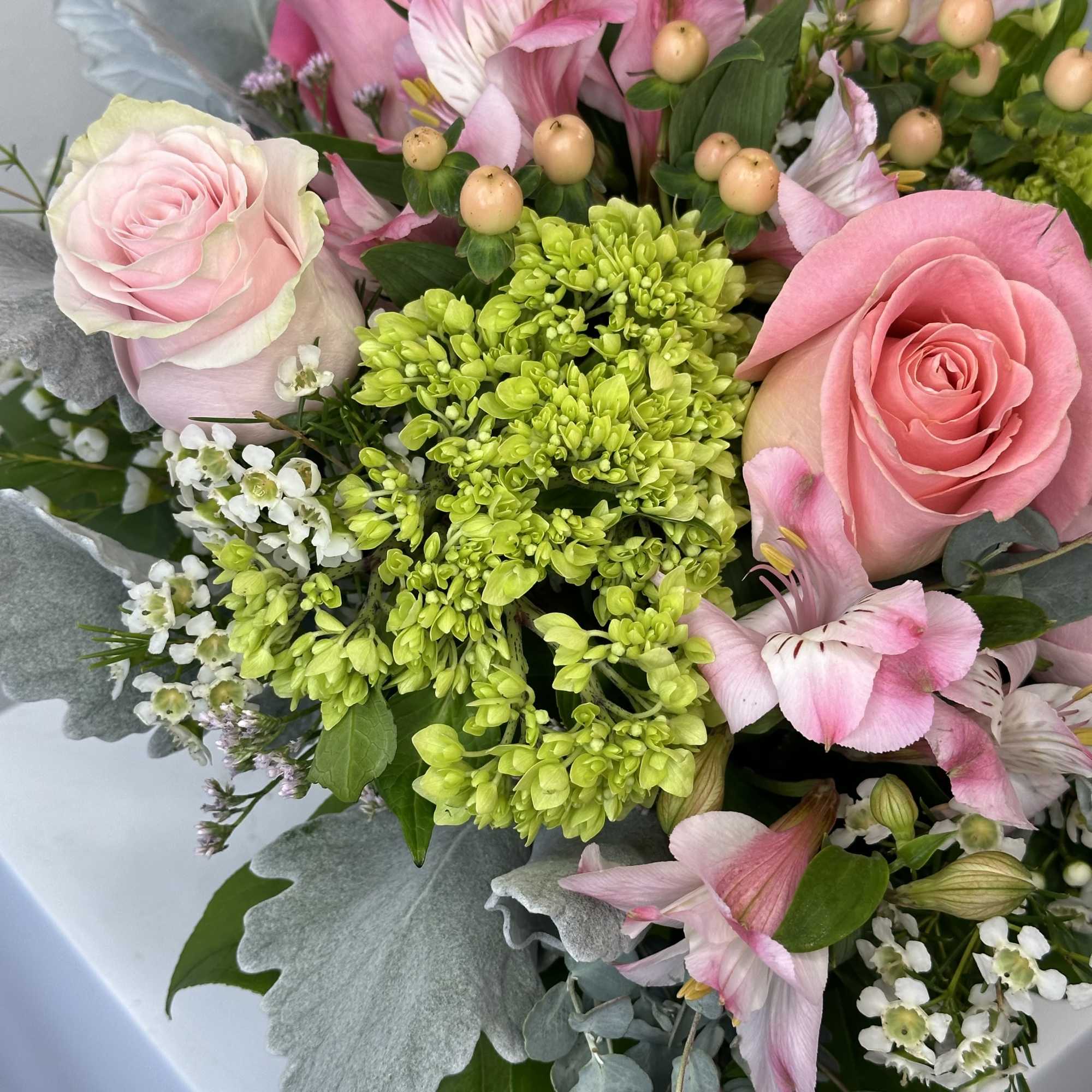 Pink roses and mixed blooms in a hand-tied bouquet