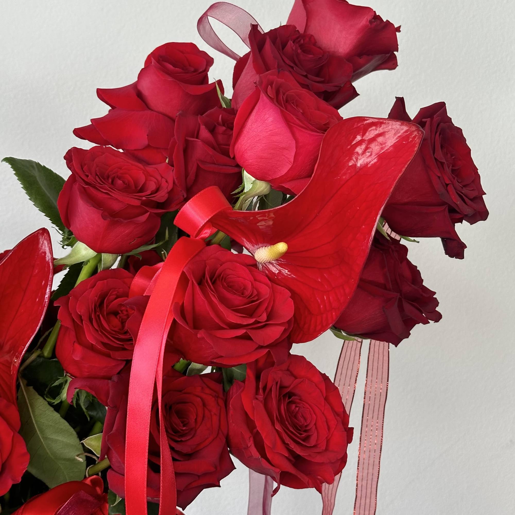 Bouquet of red roses with red ribbon and anthurium flowers