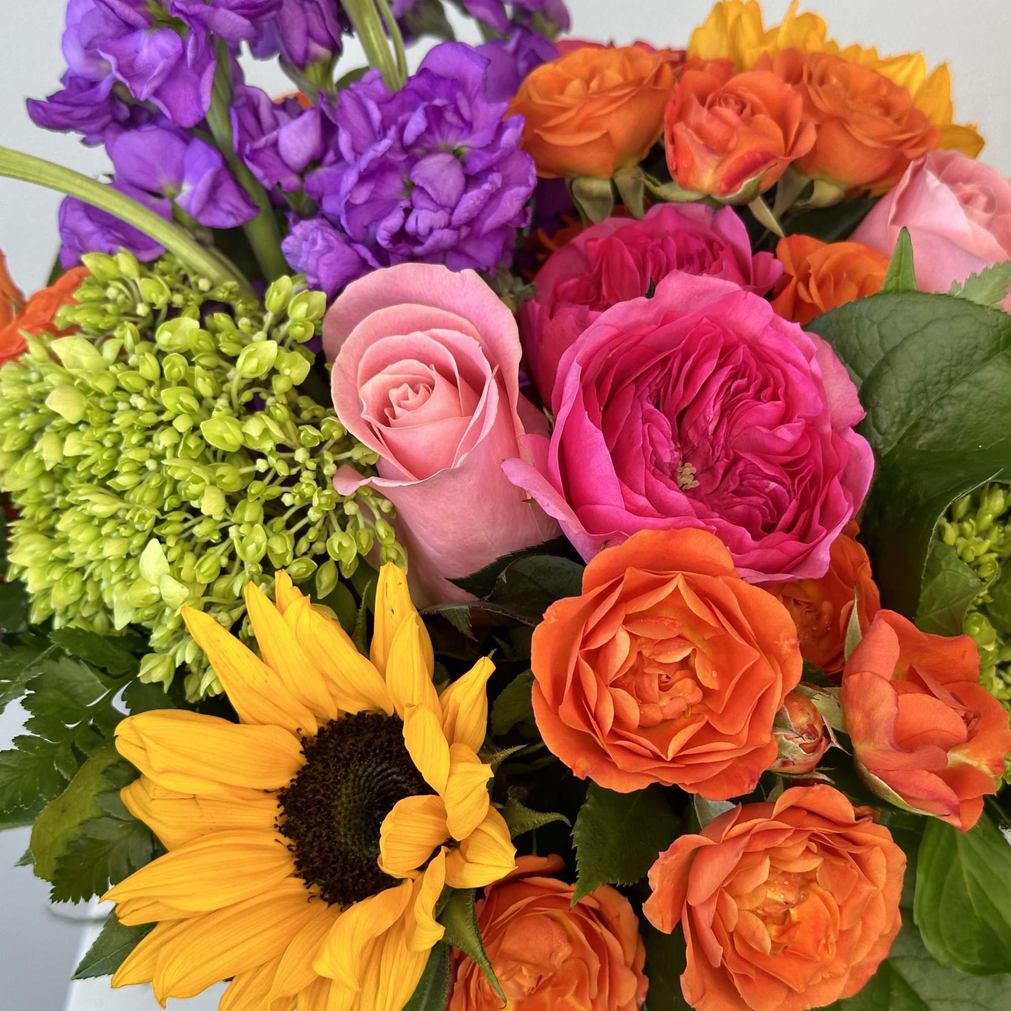 Colorful bouquet with roses, sunflowers, and purple blooms