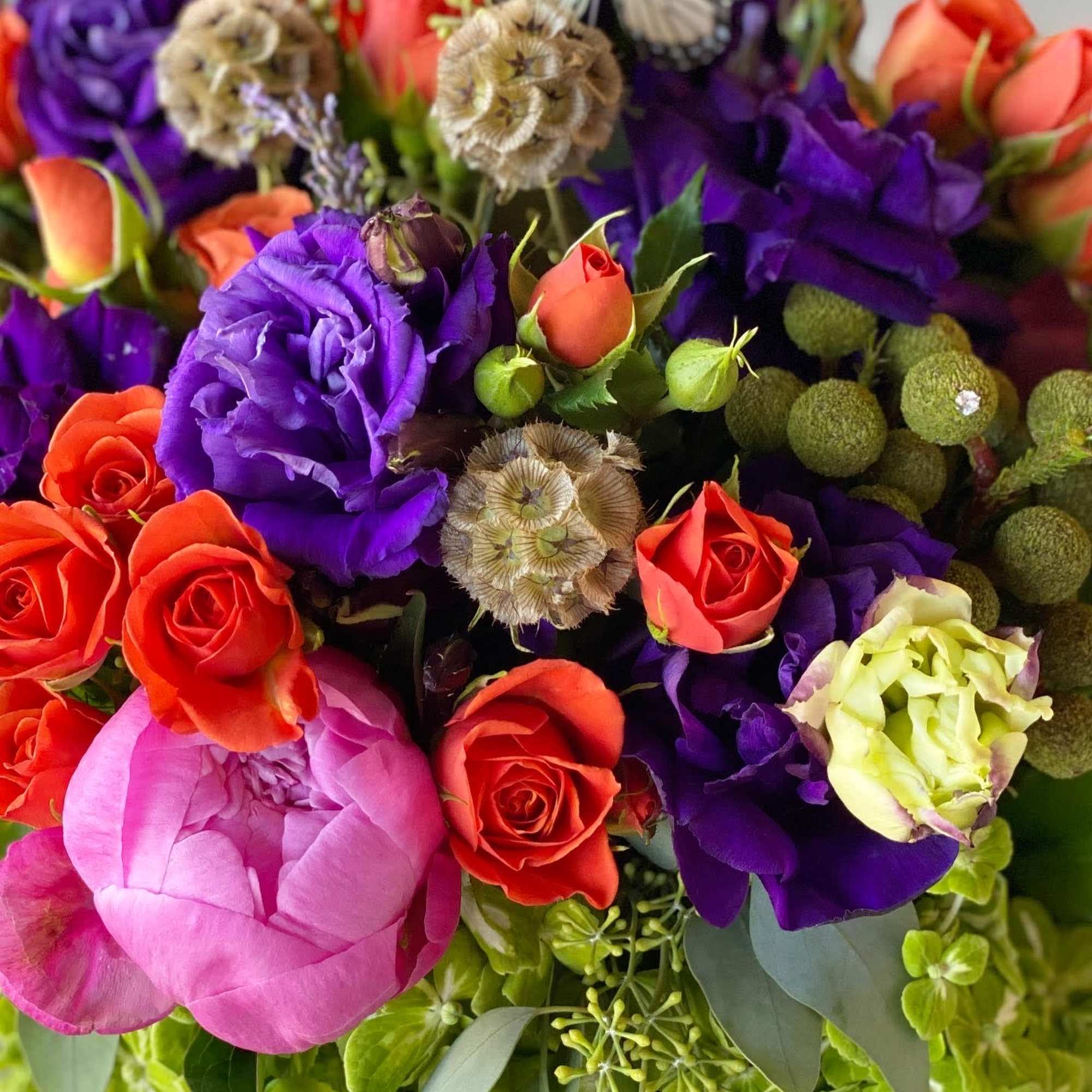 Colorful bouquet of roses and purple blooms with butterfly accents