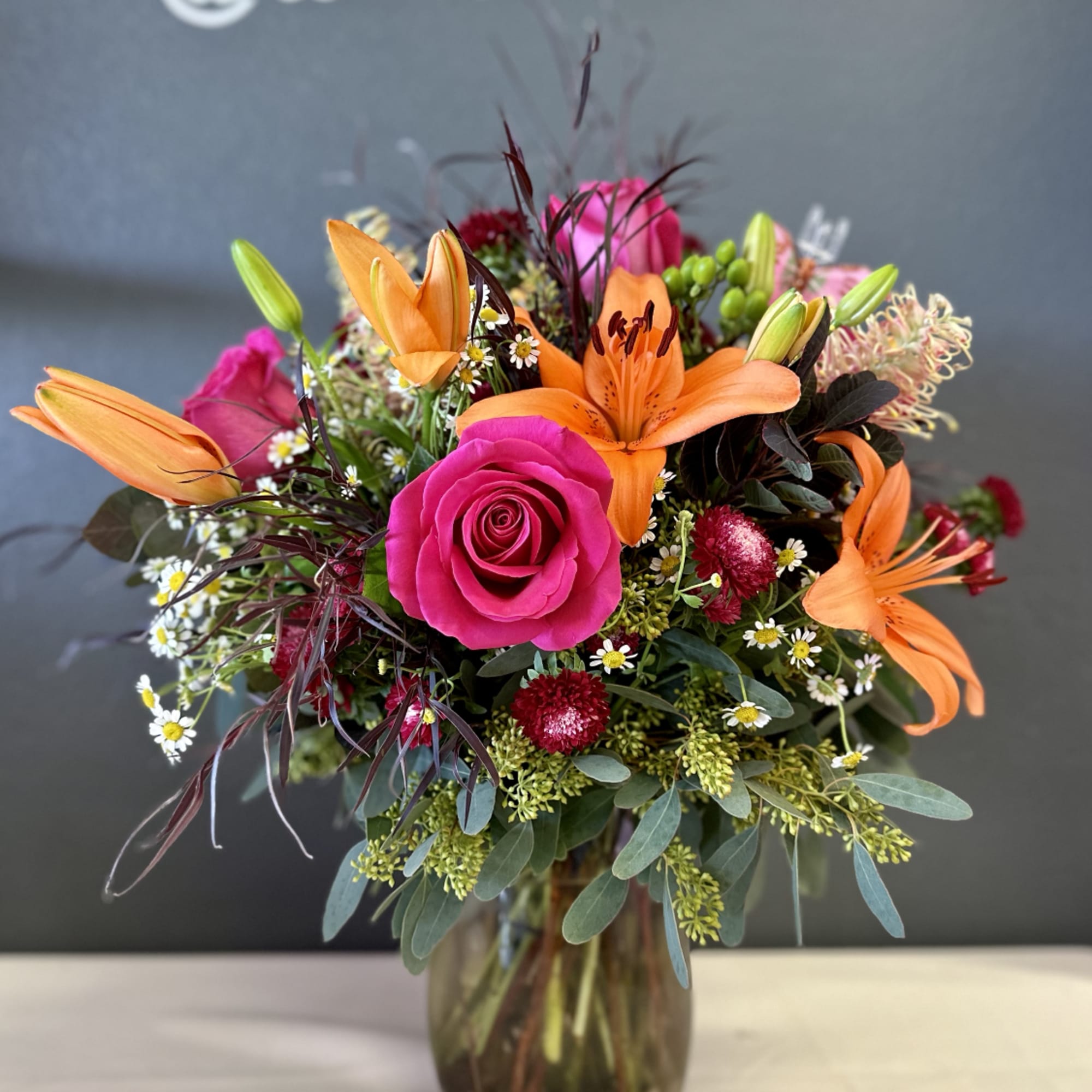 Bouquet of pink roses and orange lilies in a glass vase
