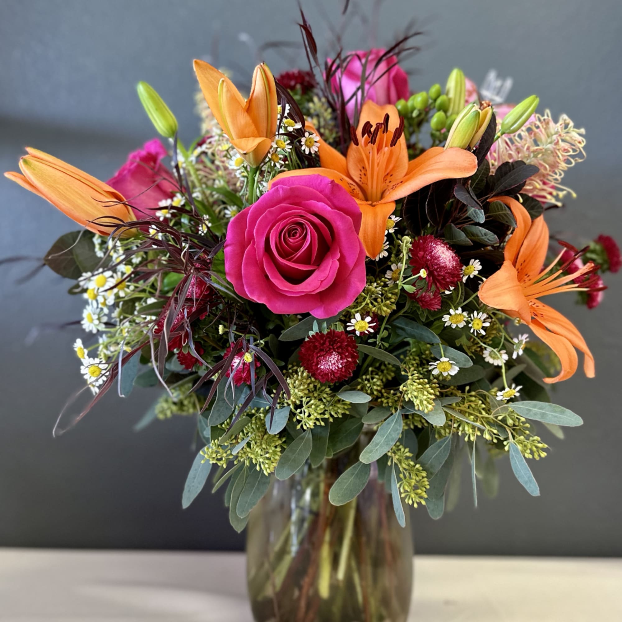 Bright mixed bouquet with pink roses and orange lilies in a glass vase, photo 4 of 4