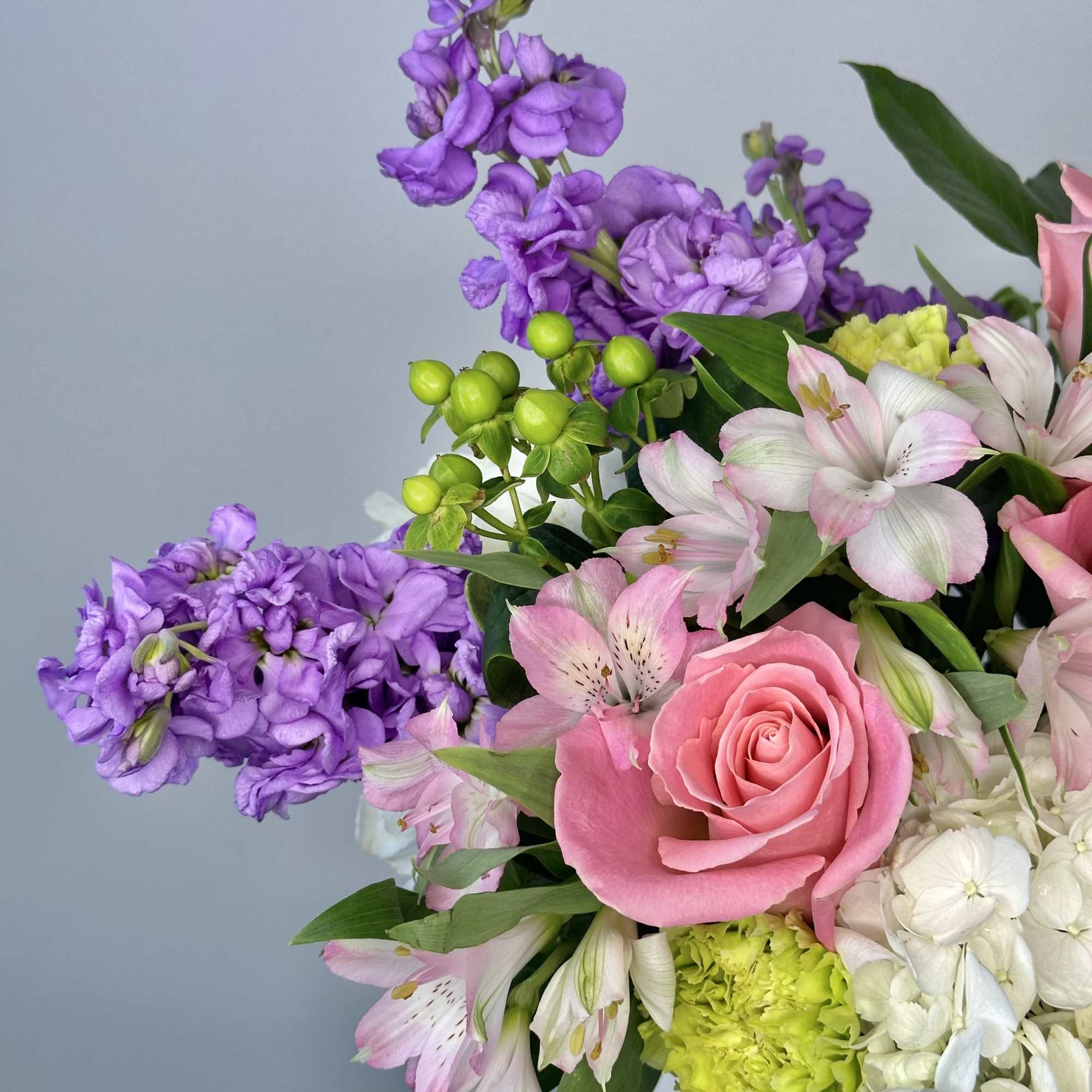 Pink roses and purple flowers in a mixed bouquet
