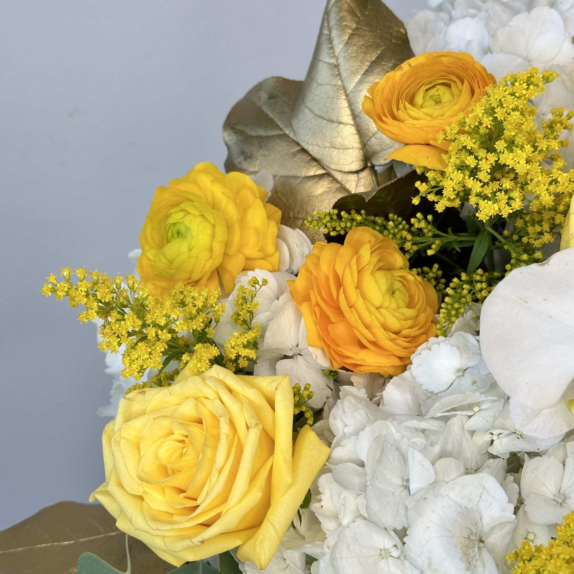 Yellow roses and white hydrangeas with gold leaves