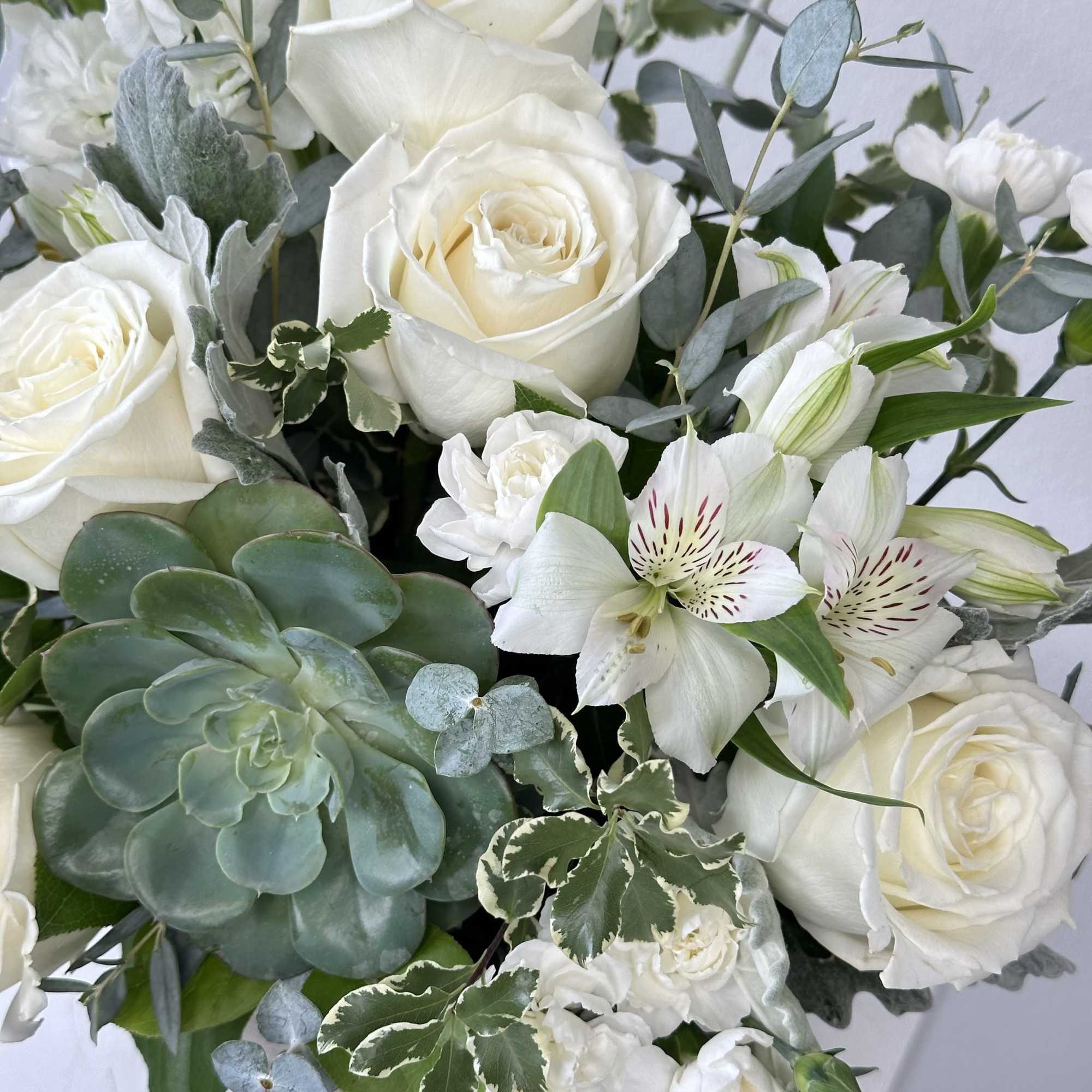 White roses and lilies with eucalyptus in a bouquet