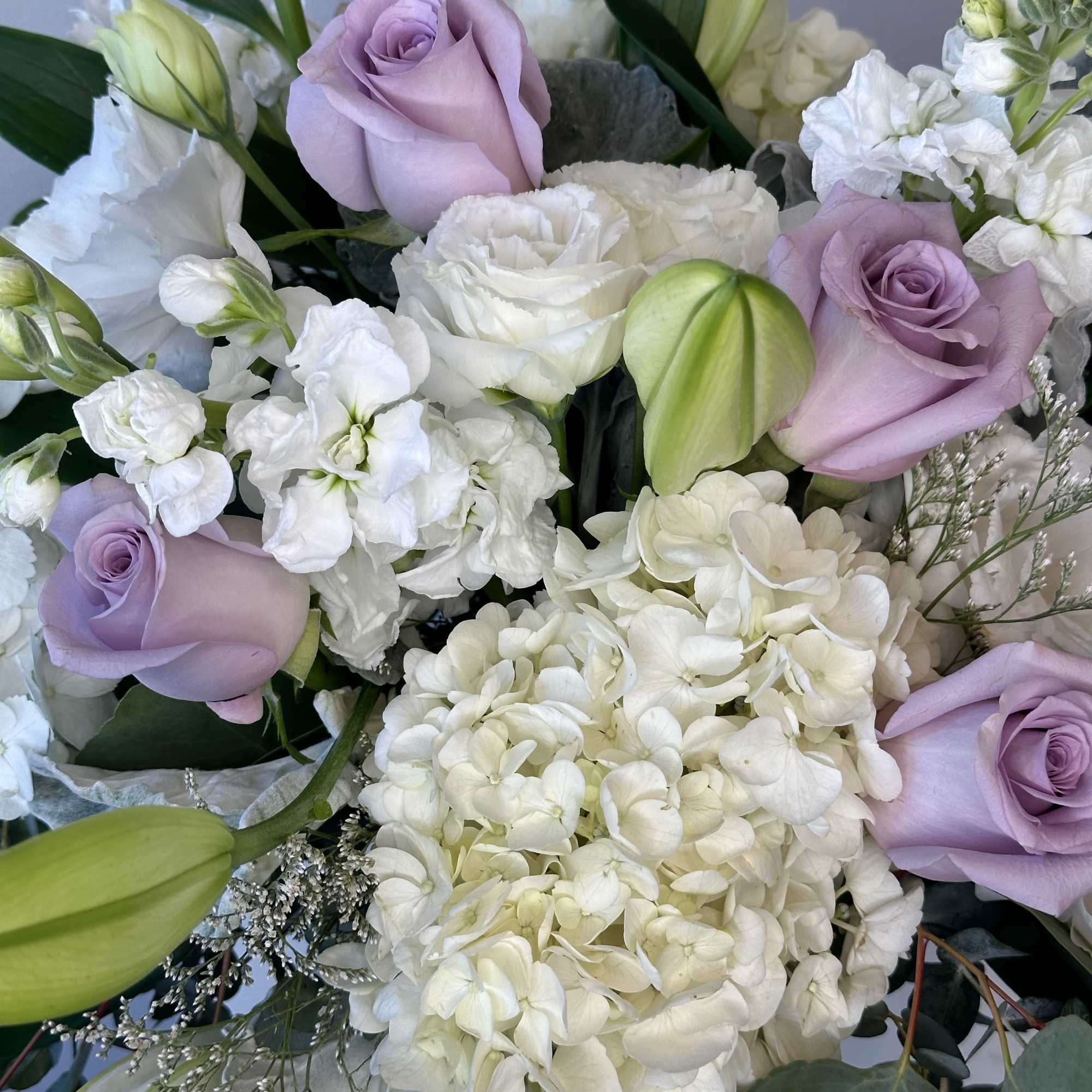 Lavender roses and white hydrangeas with pale lilies in a bouquet