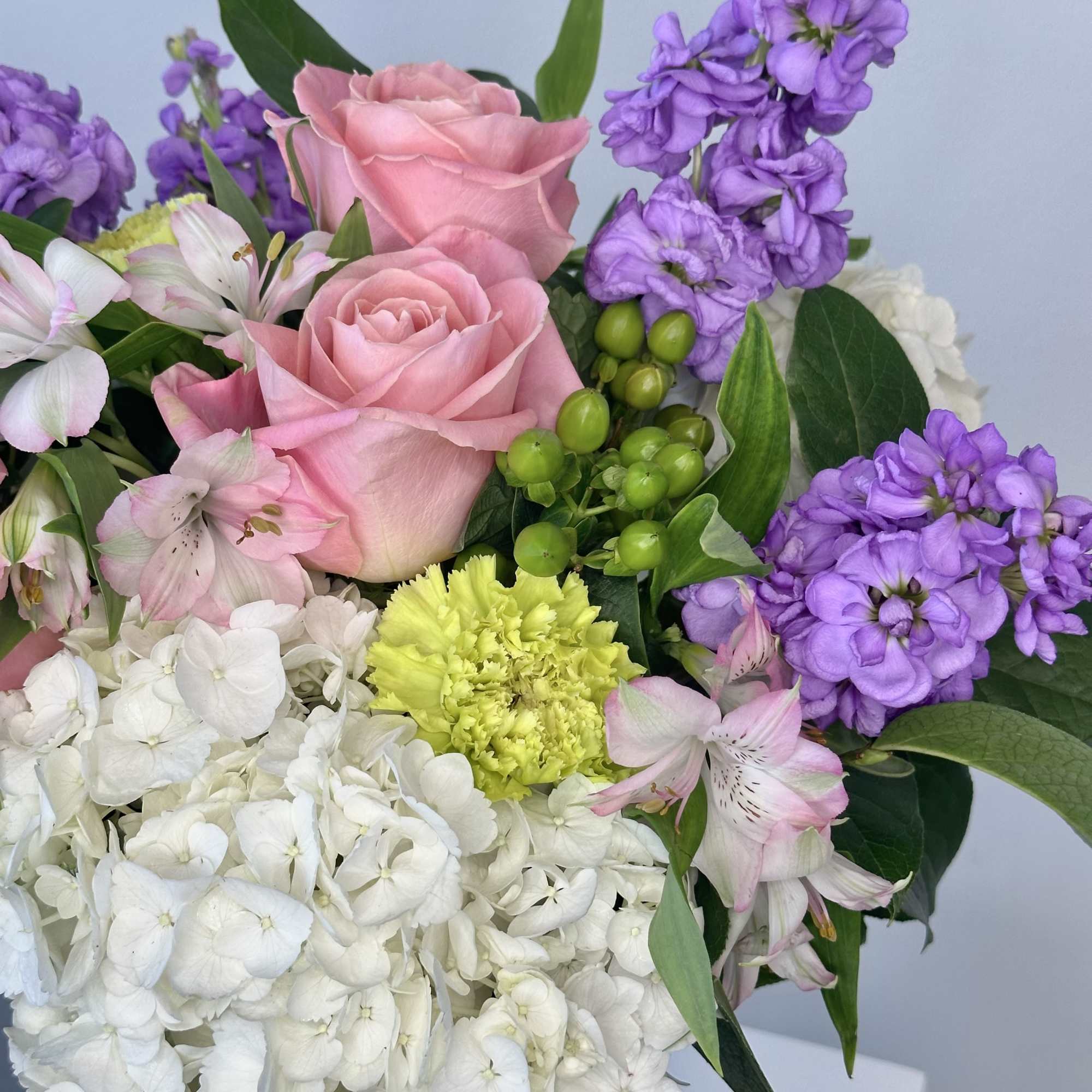 Pink roses with purple stock and white hydrangeas in a bouquet