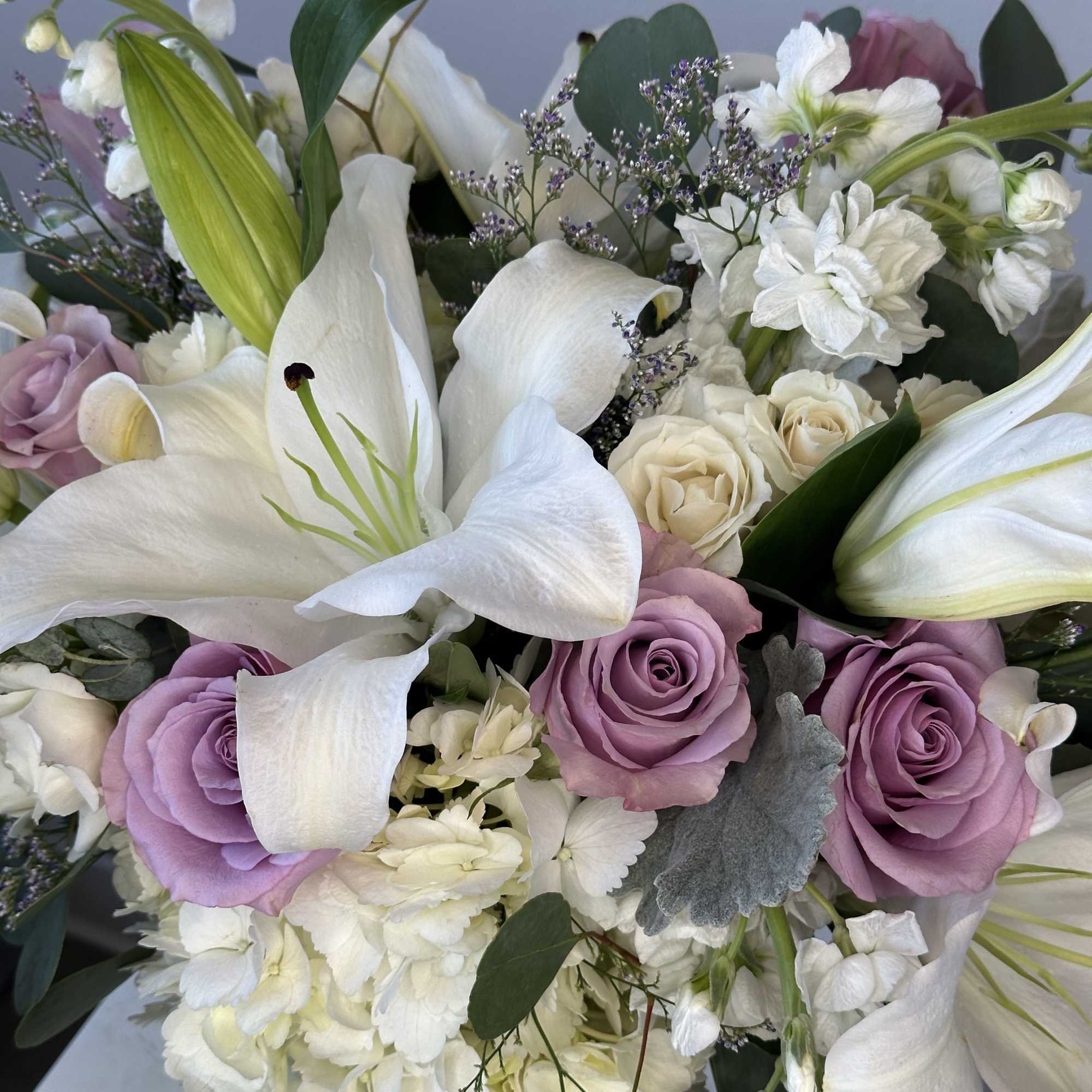 Bouquet of white lilies and lavender roses with white filler flowers