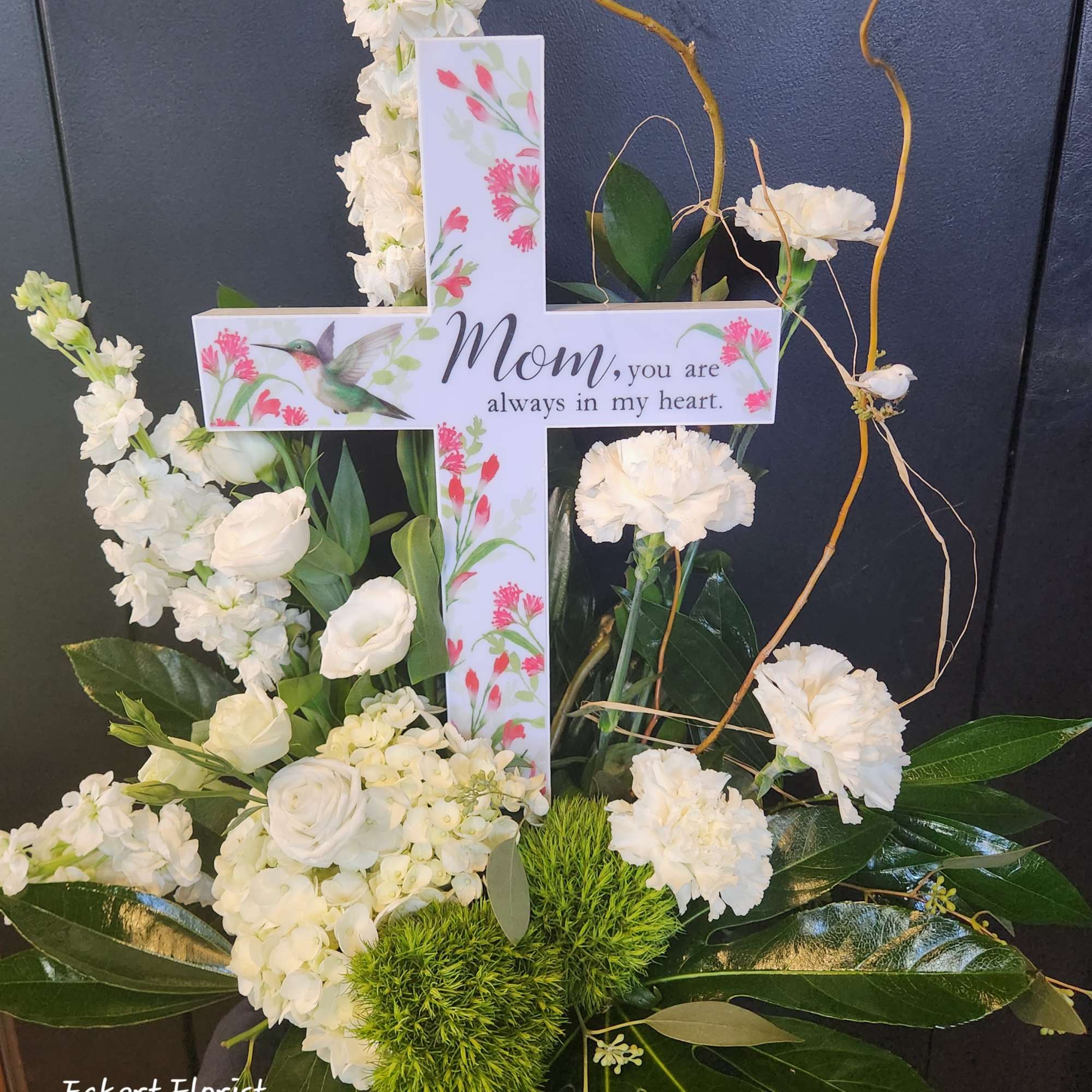 White floral cross arrangement with a Mom memorial card