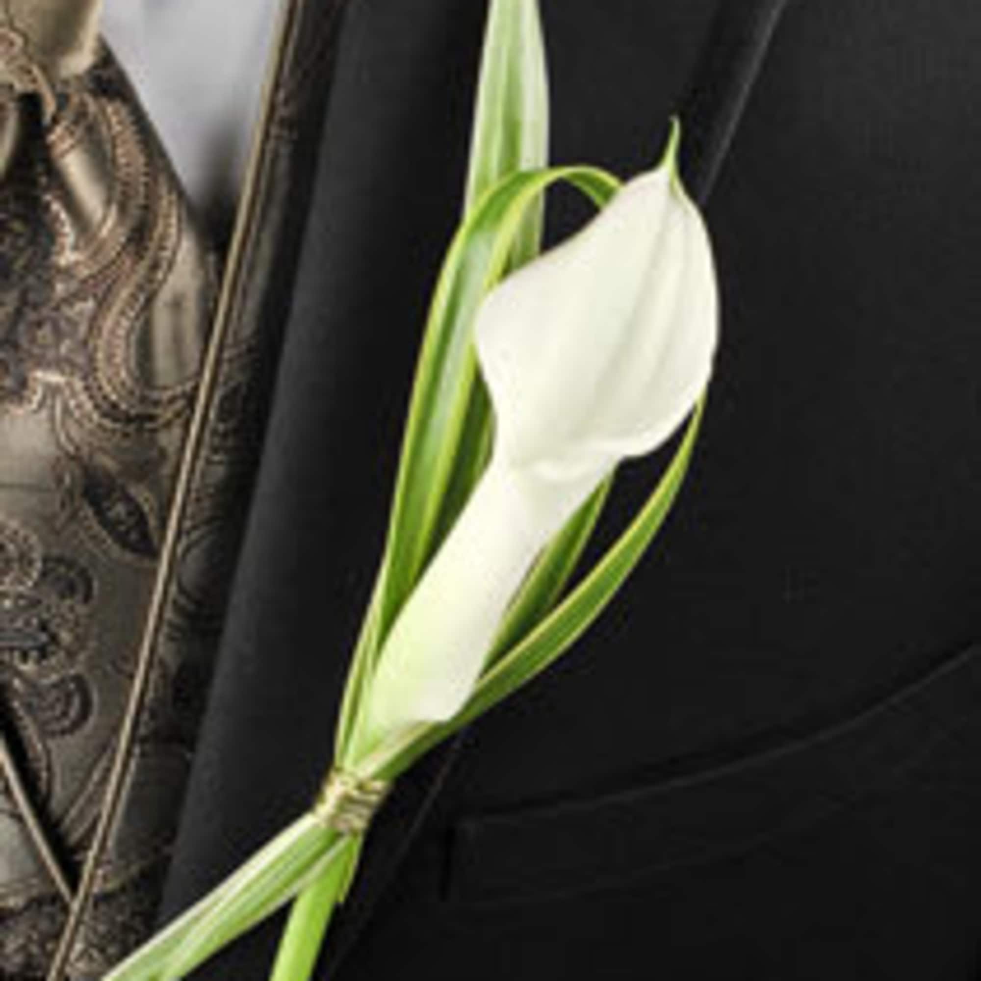 White calla lily boutonniere on a black jacket