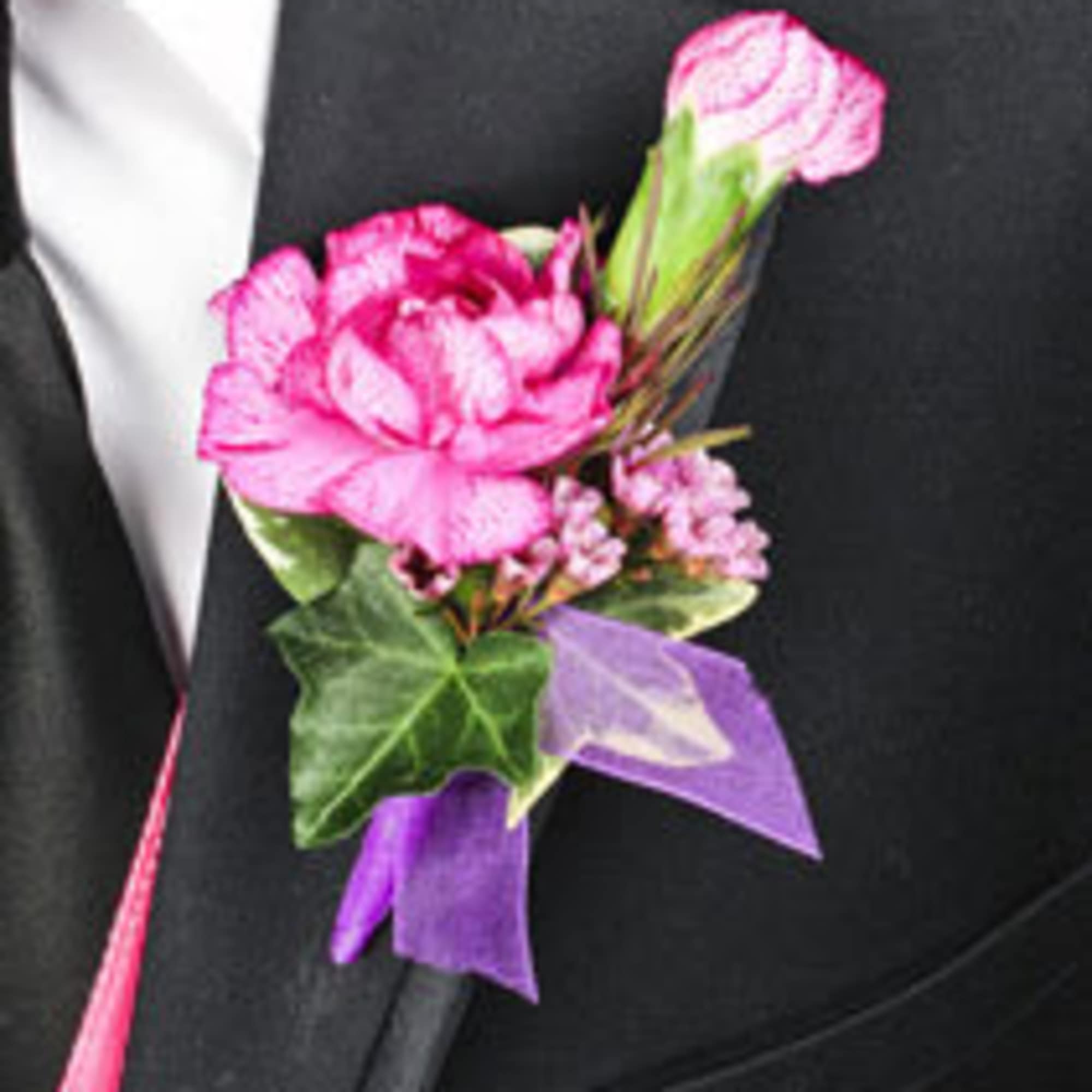 Pink boutonniere with a ribbon on a black suit lapel