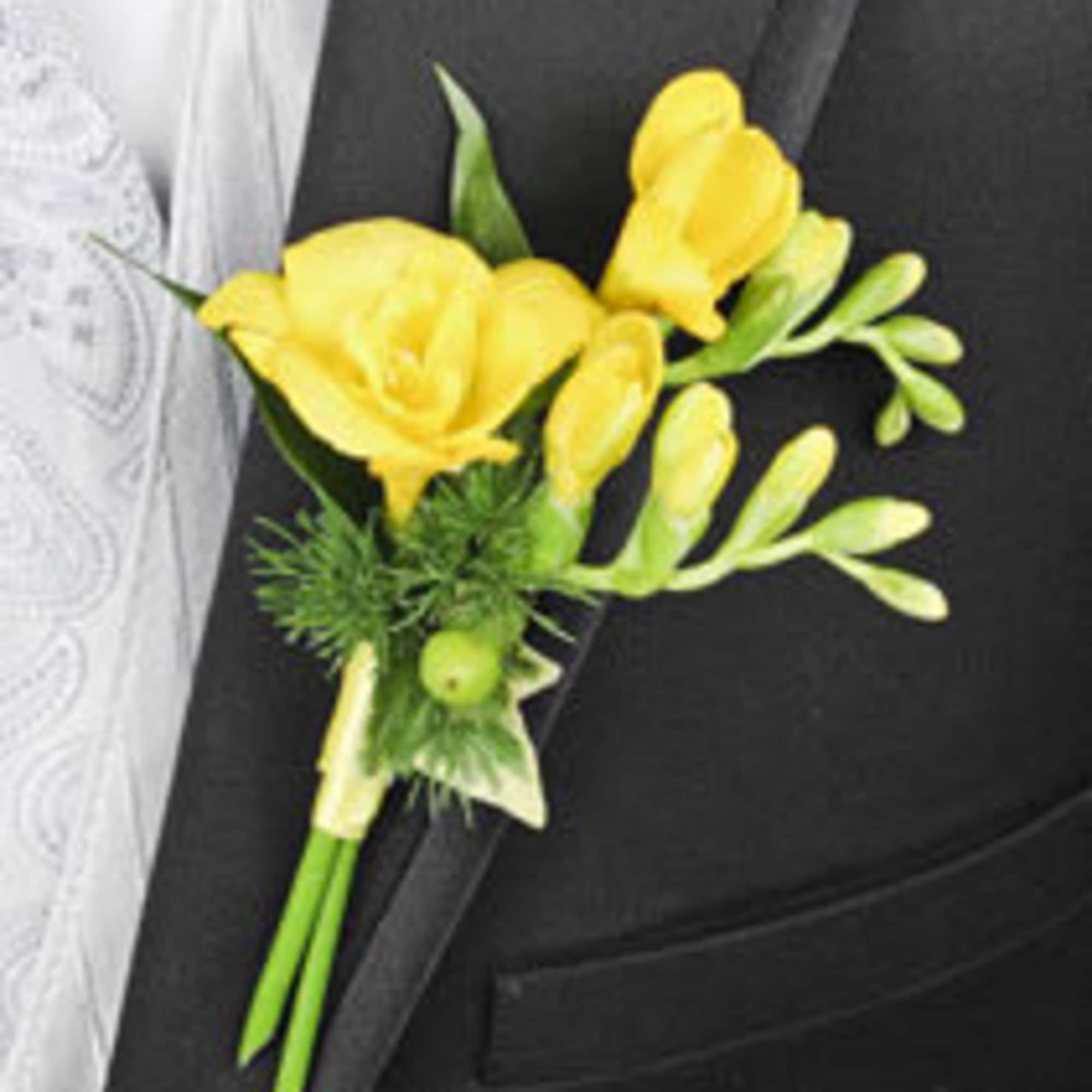 Yellow boutonniere with small green accents on a black suit lapel