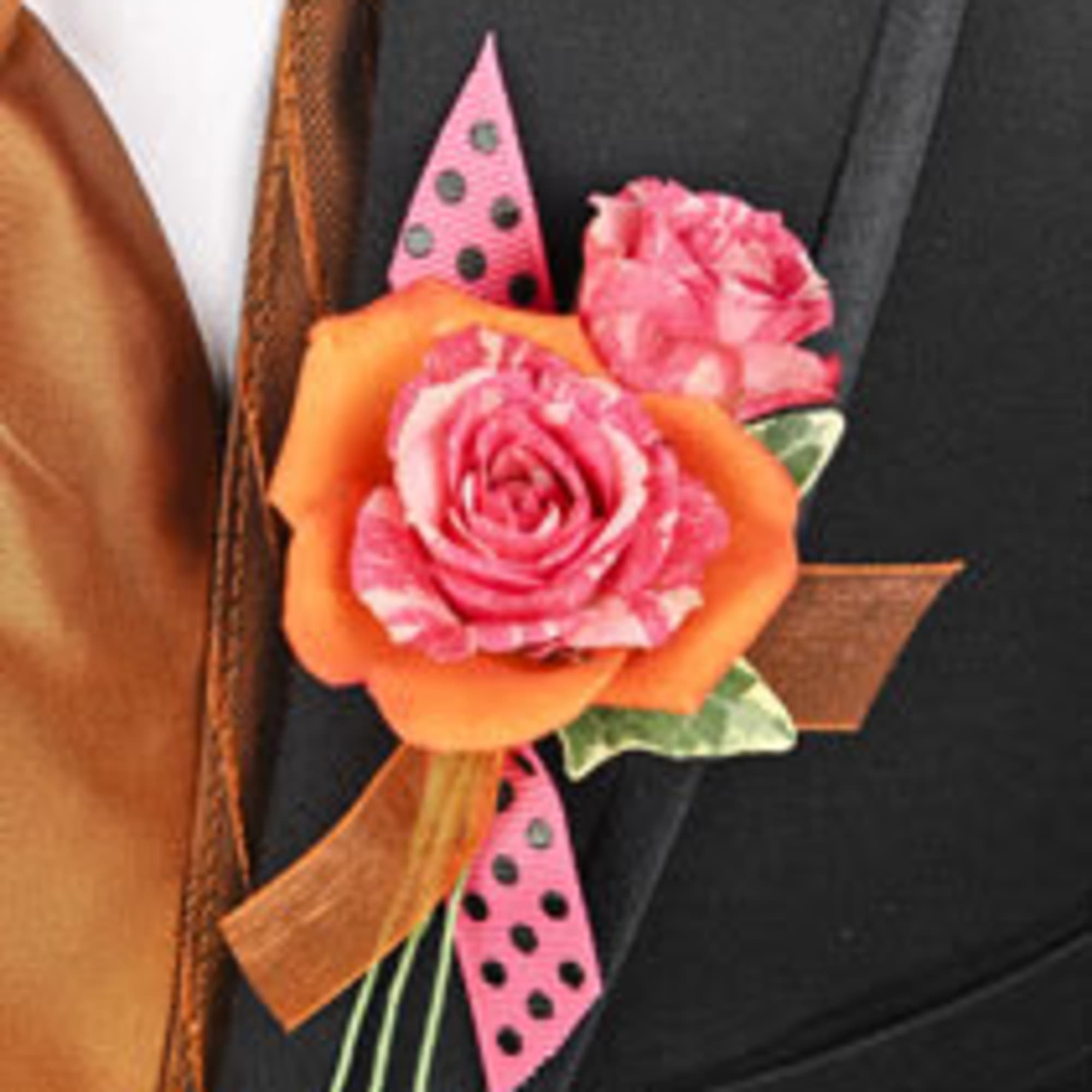 Pink and orange rose boutonniere with polka-dot ribbon