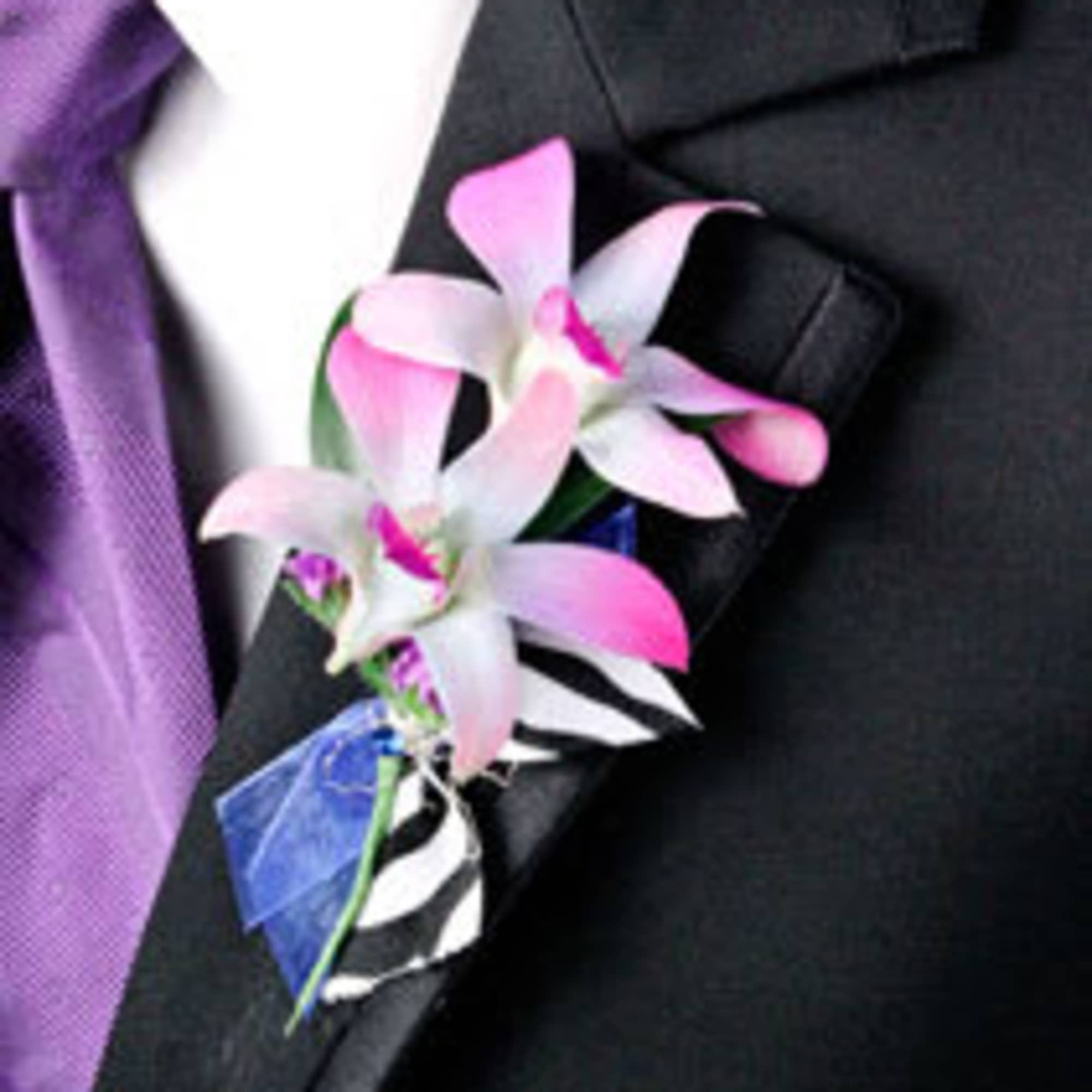 Pink and white orchid boutonniere on a black suit lapel