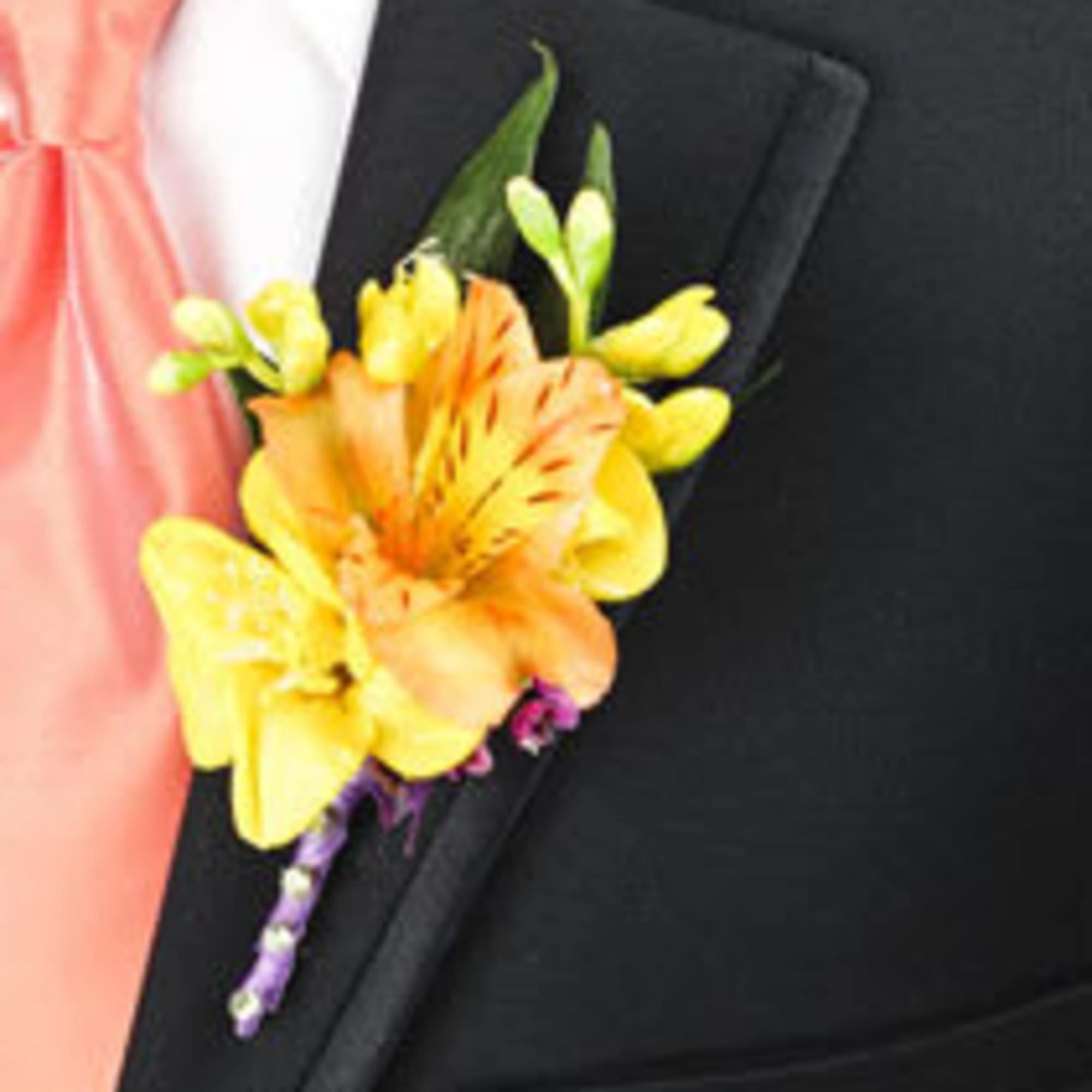 Yellow and orange boutonniere pinned to a black suit jacket