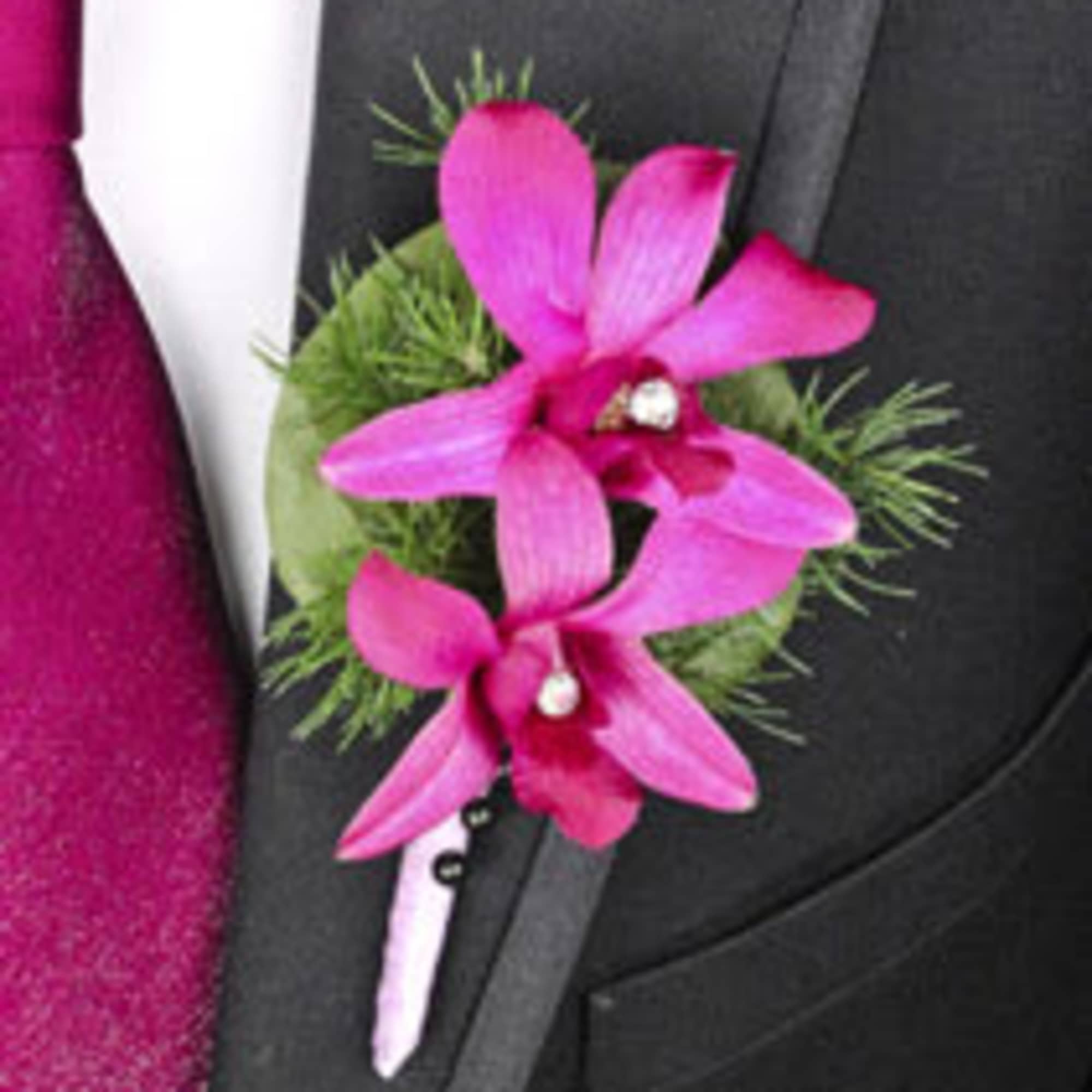 Pink orchid boutonniere pinned to a black suit jacket, photo 11 of 19