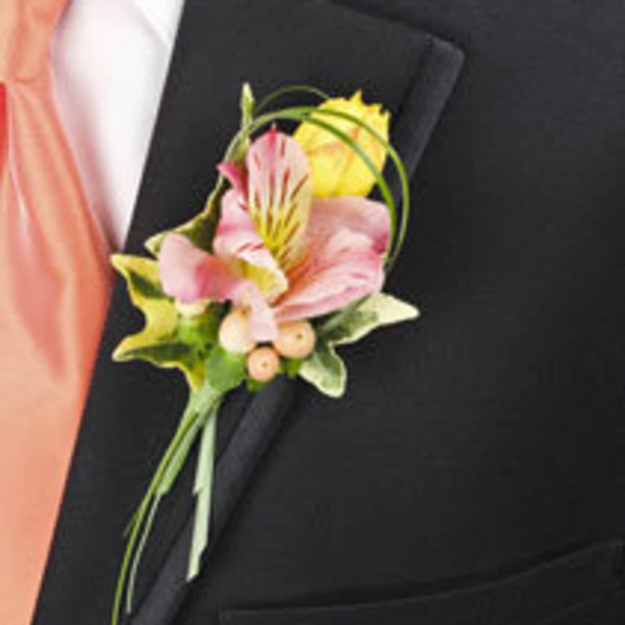 Pink and yellow boutonniere pinned to a black suit lapel