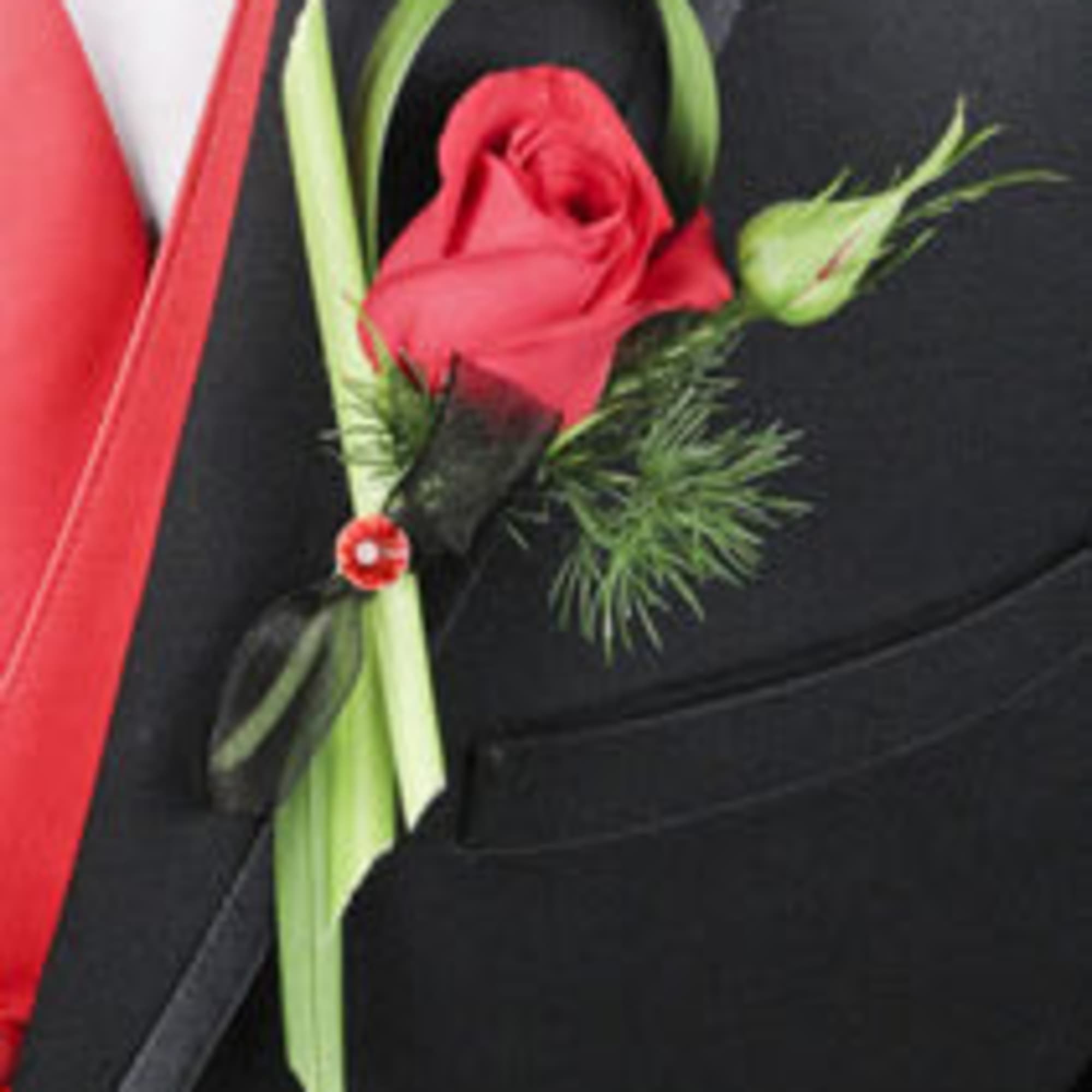 Red rose boutonniere pinned to a black suit jacket