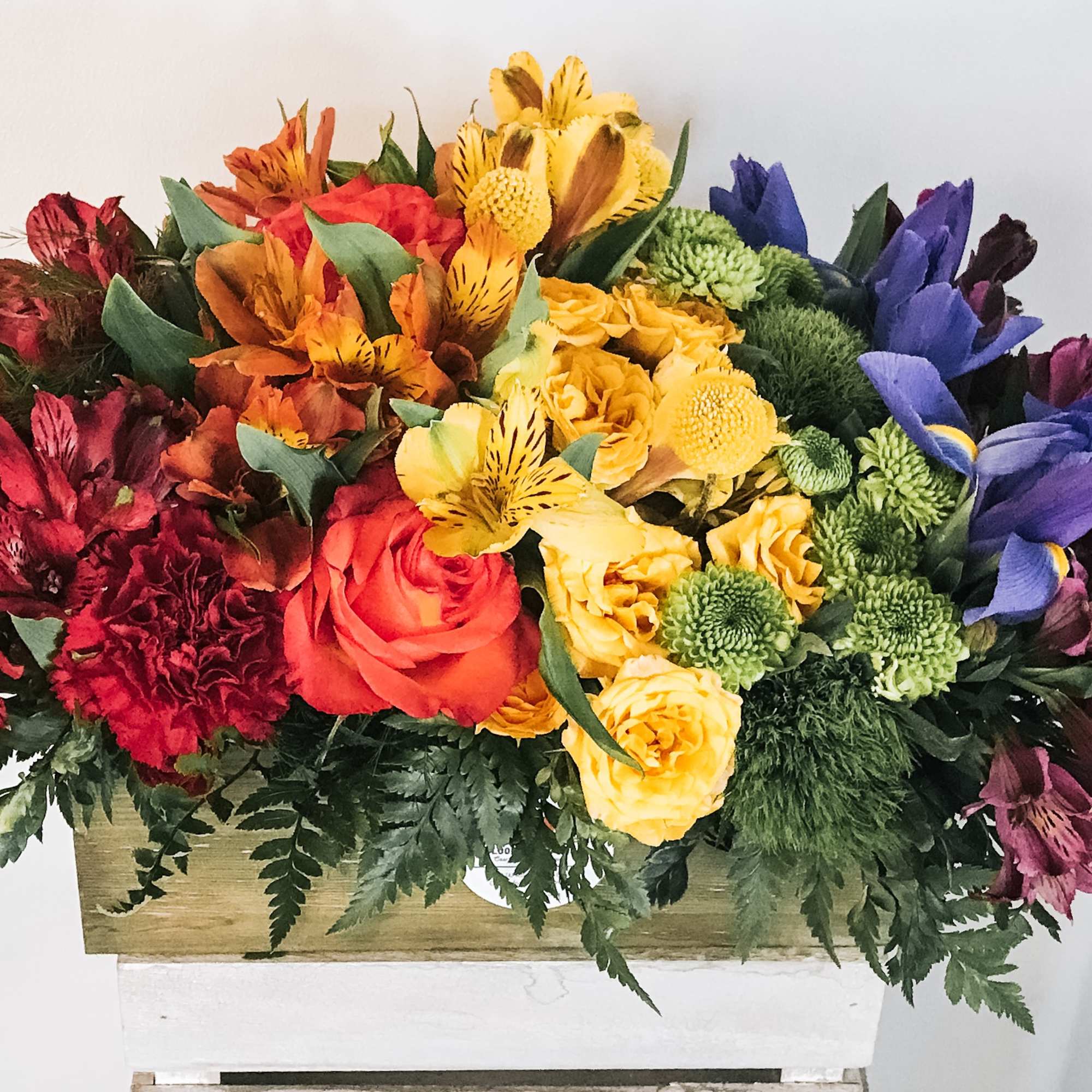 Colorful mixed bouquet with roses, alstroemeria, and mums in a wooden box