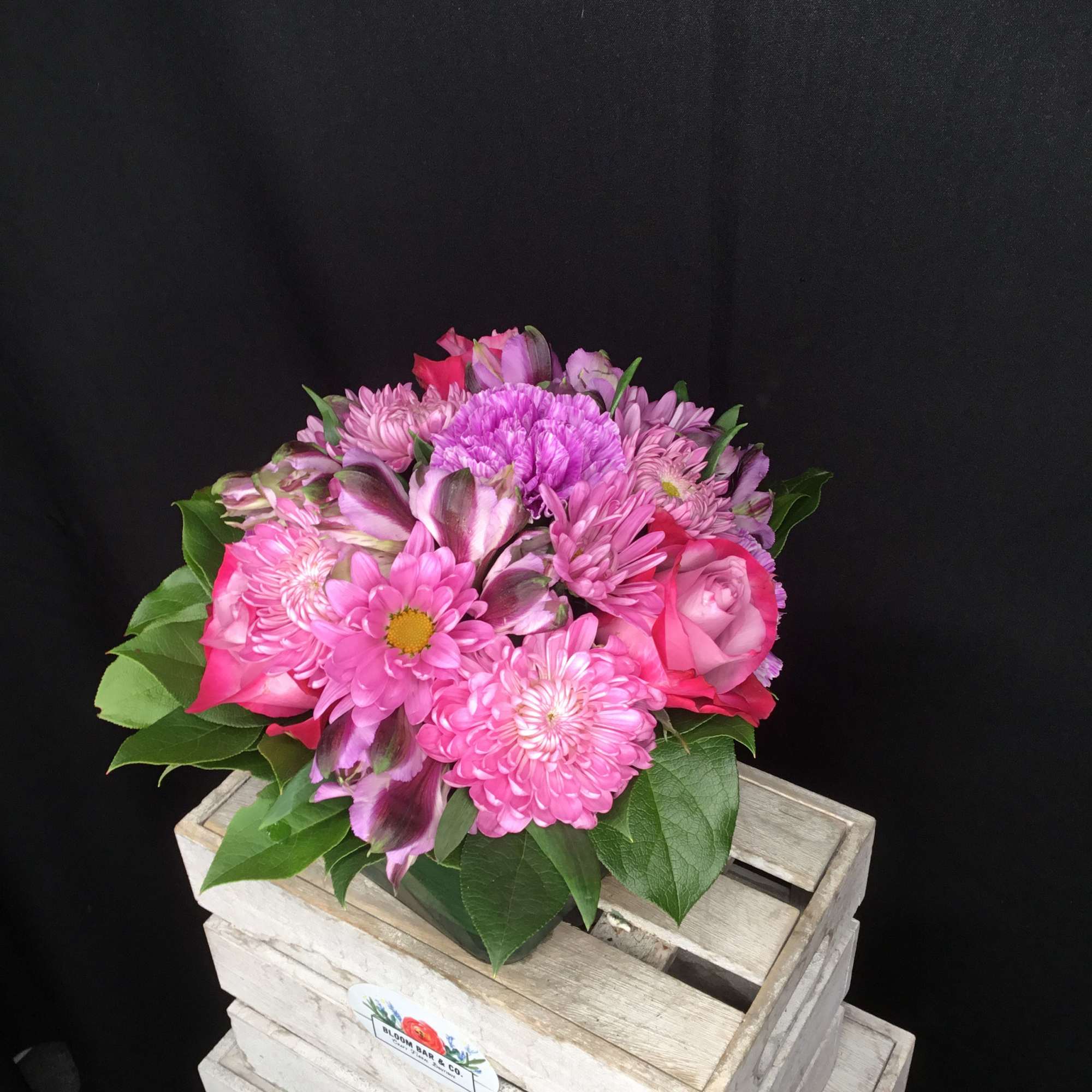Pink mixed flower bouquet in a wooden crate