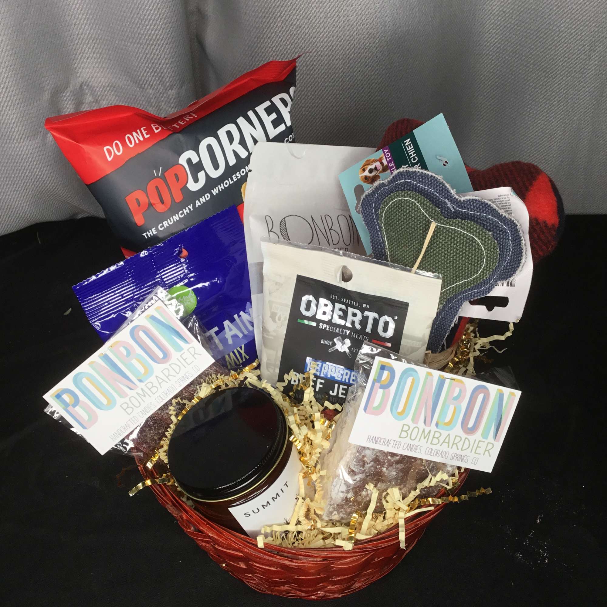 Gift basket with snacks, jerky, candy, and a candle