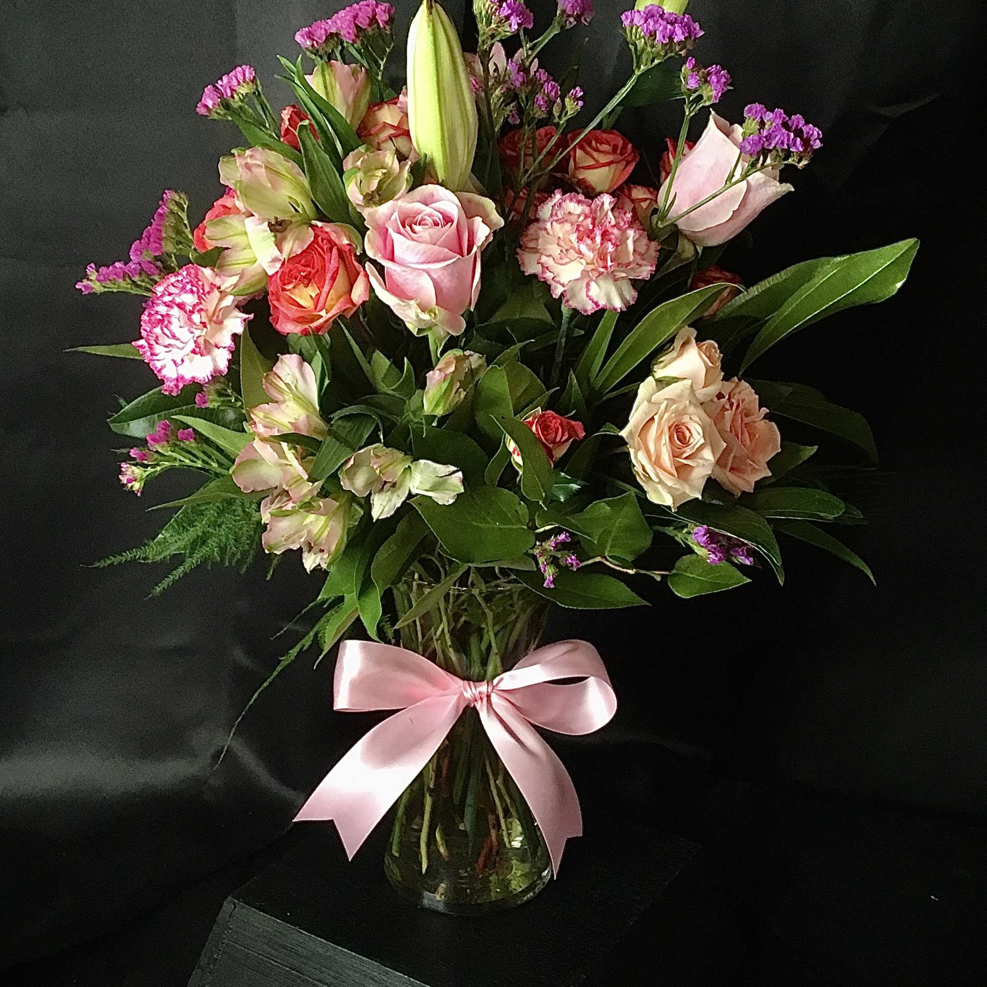 A fun, festive mix of pretty pink blossoms &ndash; including roses, lilies