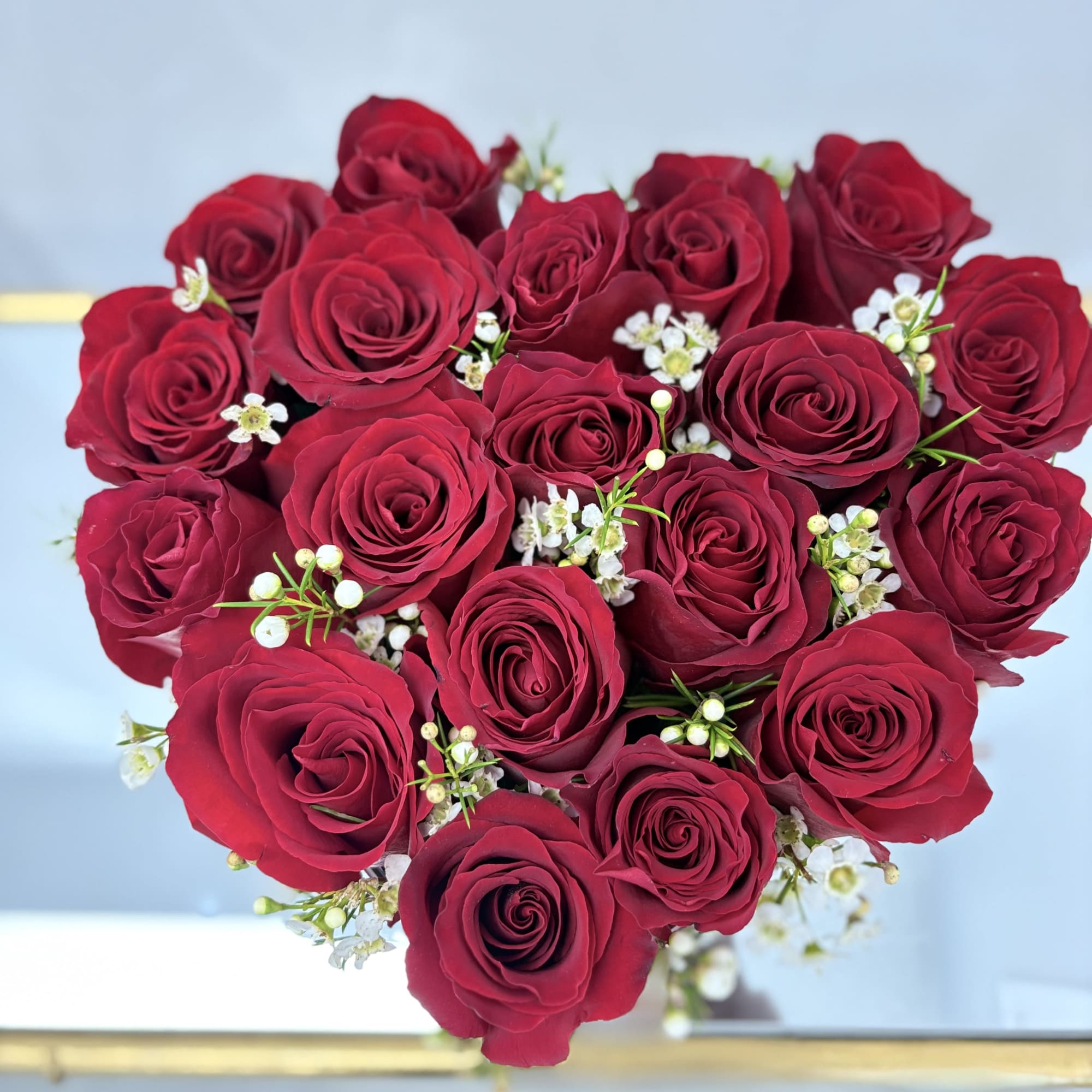 Bouquet of deep red roses with small white filler flowers